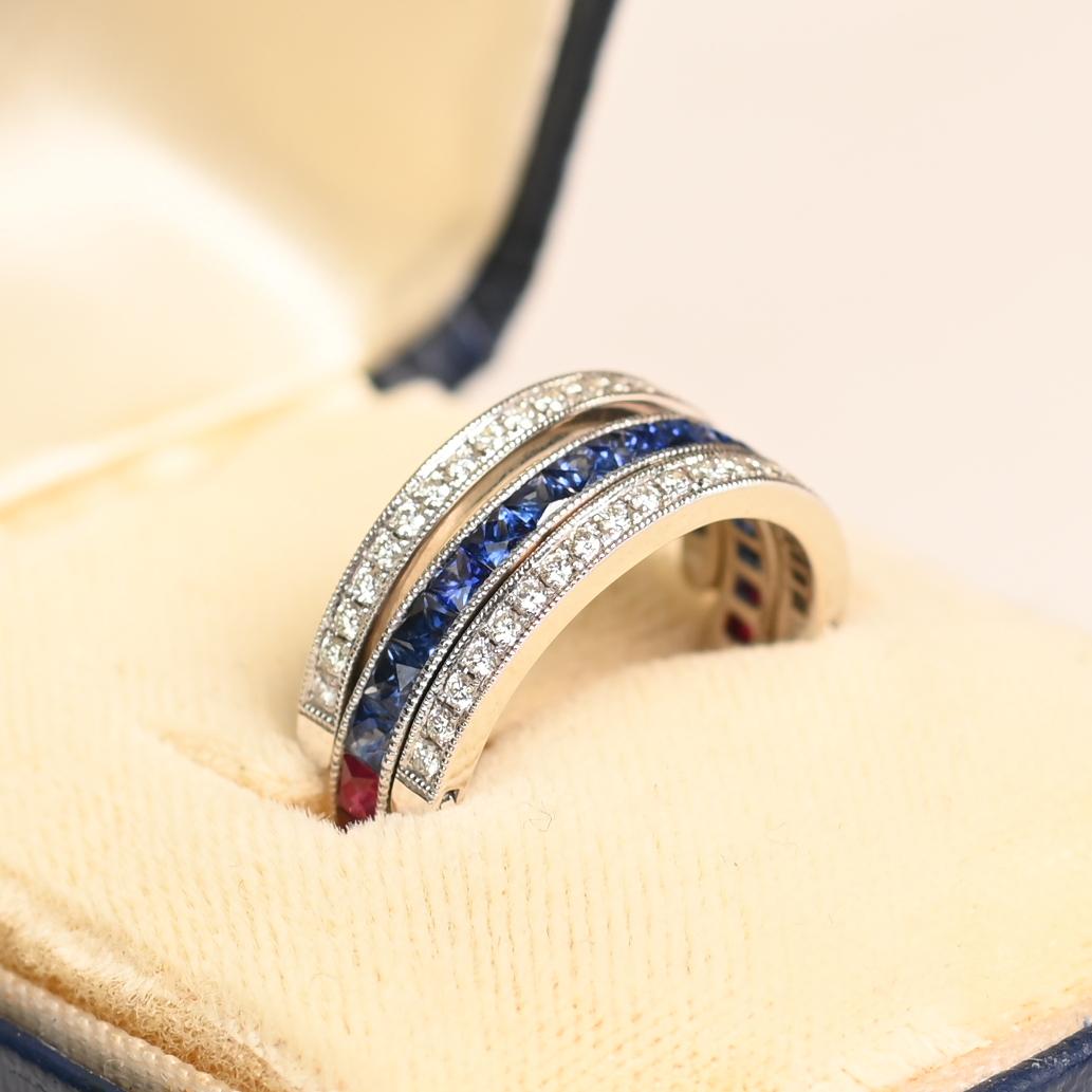 Este exquisito anillo de oro blanco de 14 quilates muestra una sorprendente combinación de zafiros talla francesa, rubíes y diamantes redondos talla brillante. Diseñadas con un meticuloso trabajo artesanal, las piedras preciosas están dispuestas en