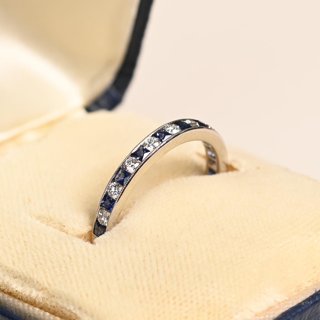 Questa elegante fascia a mezza altezza è un pezzo senza tempo realizzato in platino e impreziosito da zaffiri naturali a taglio francese e diamanti rotondi a taglio brillante. Il motivo alternato di zaffiri e diamanti aggiunge un bellissimo