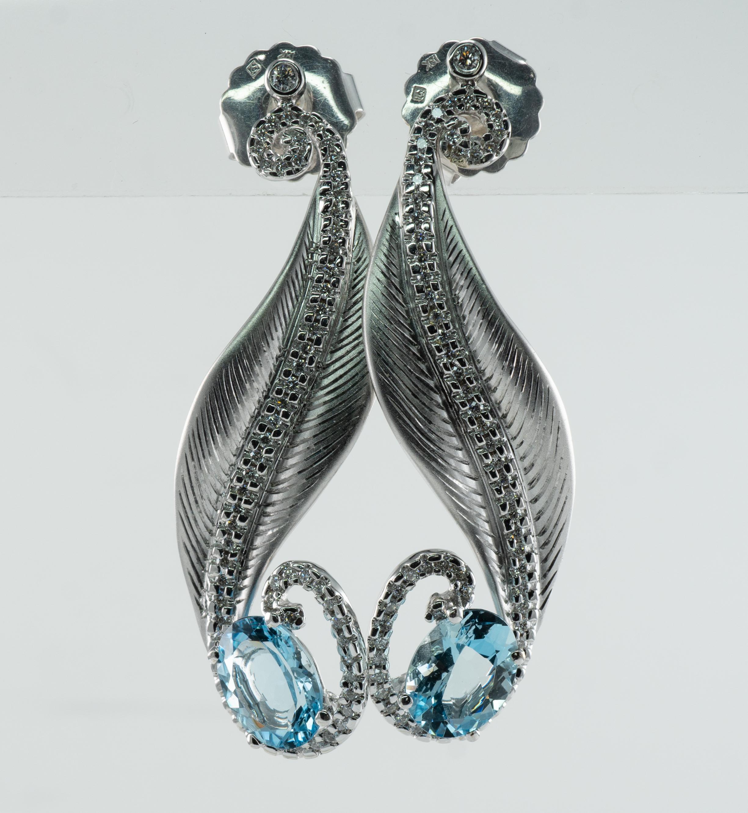 These gorgeous estate earrings are finely crafted in solid 18K White gold. 
They are set with natural Earth mined Aquamarines and diamonds. 
Each oval cut Aquamarine is 9x7mm totaling 3.50 carats for the pair.
These gems are very clean and