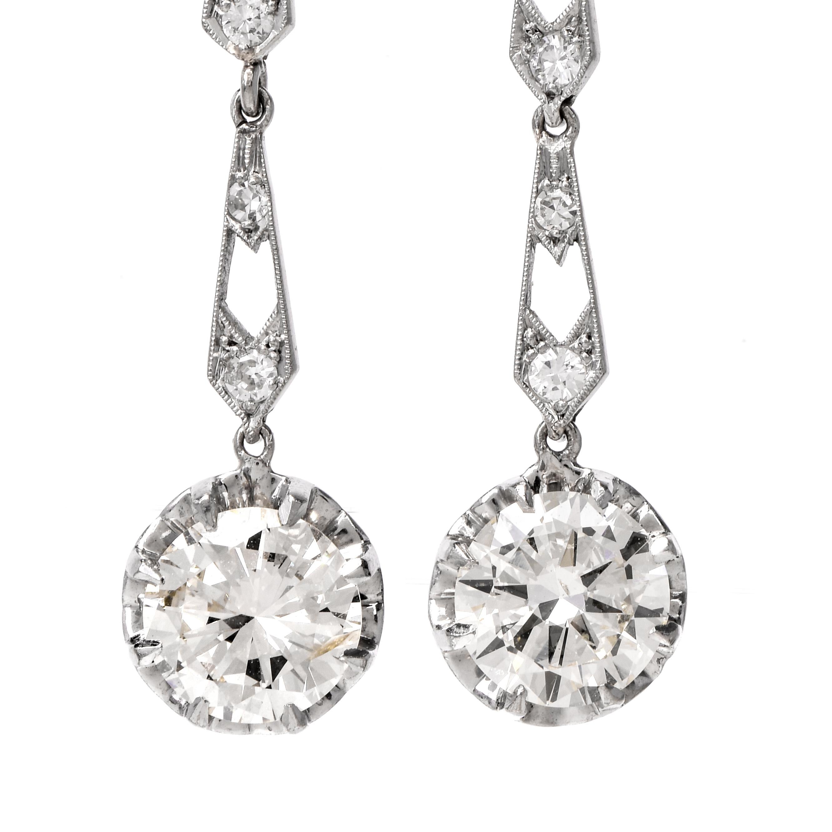 These stunning vintage diamond dangle drop earrings are crafted in solid platinum, weighing 6 grams and measuring 1 1/2” long x 10mm wide. Drops are prong-set with a pair of round-cut diamonds, weighing approximately, 3.95 carats in total, graded J