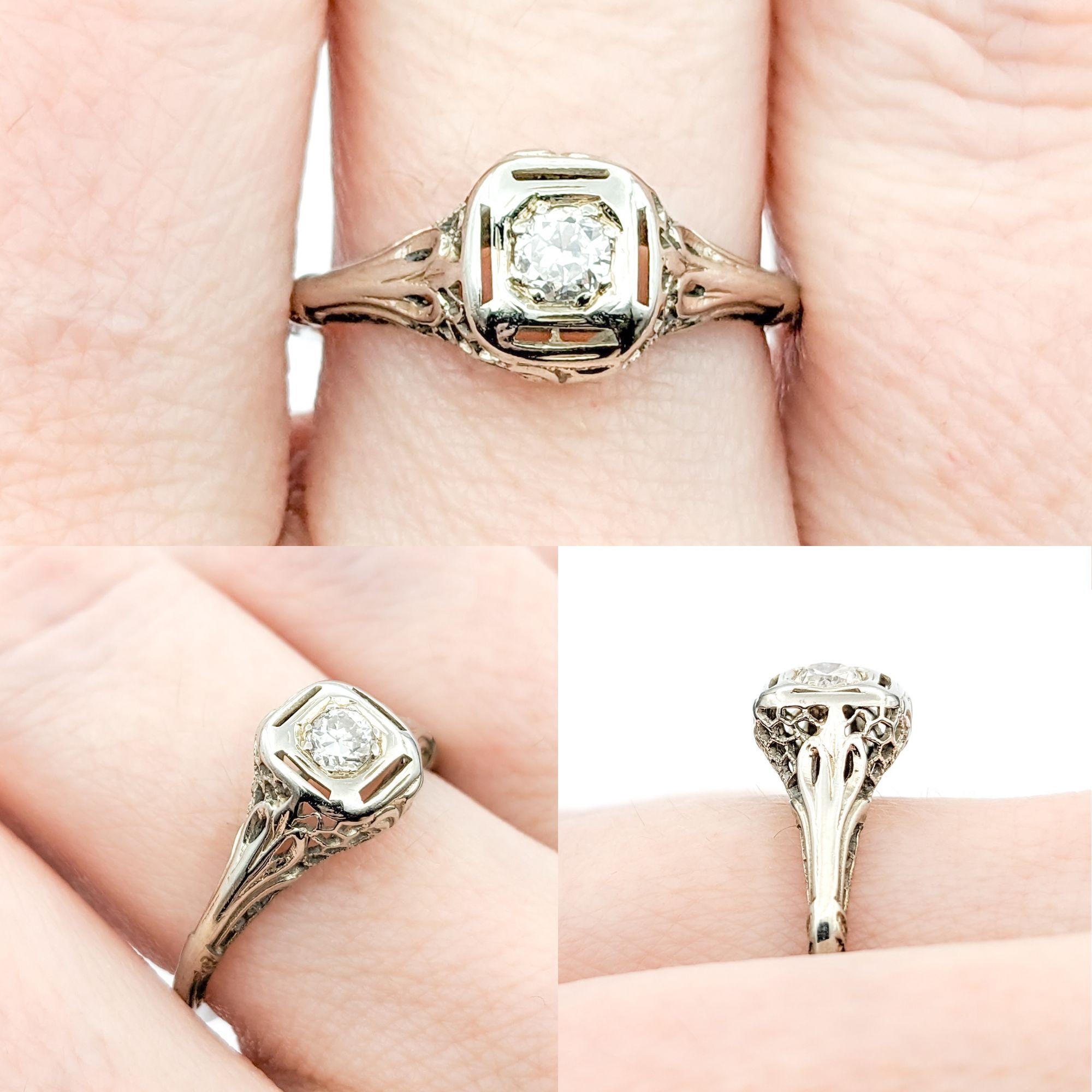 Diamond Art Deco Filigree Ring In White Gold

Introducing this beautiful Antique Ring crafted in 18k white gold. This Art Deco Filigree ring elegantly showcases a .15ct Old European Diamond as its centerpiece, combining vintage charm with a touch of