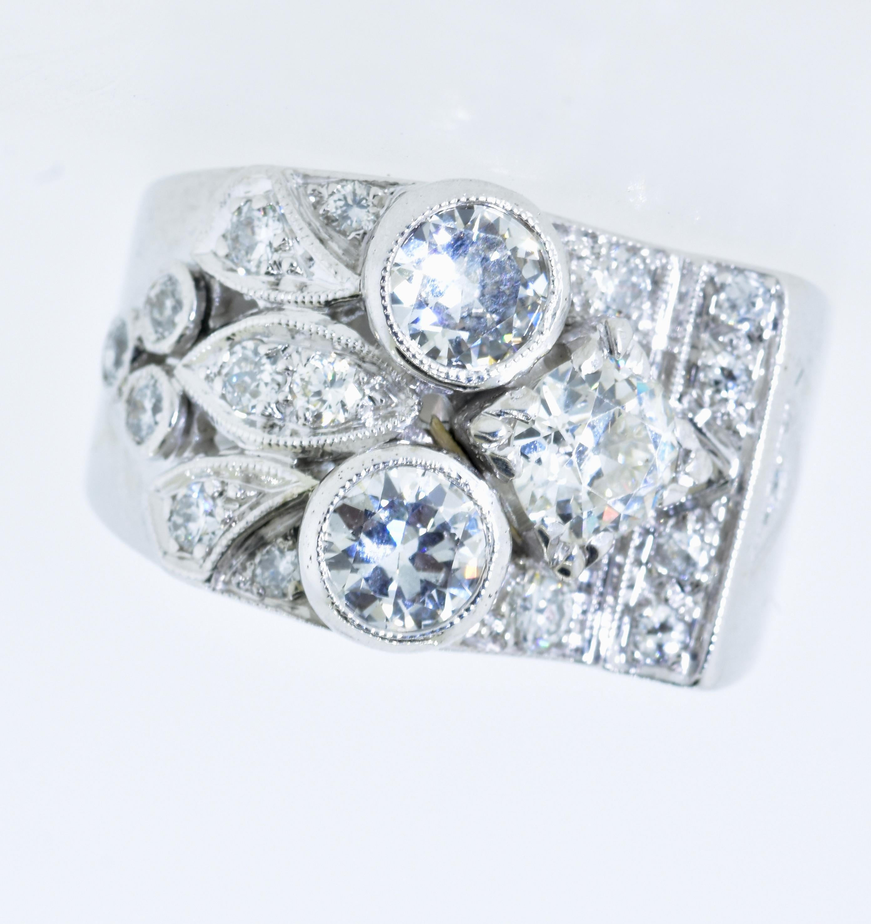 Diamonds set in a wide hand made ring. The 3 large European cut diamonds are accent with smaller diamonds.  All of the diamonds are near colorless, (I) and very slightly included, (VS).  The total diamond weight has been estimated to be 3.0 cts. 
