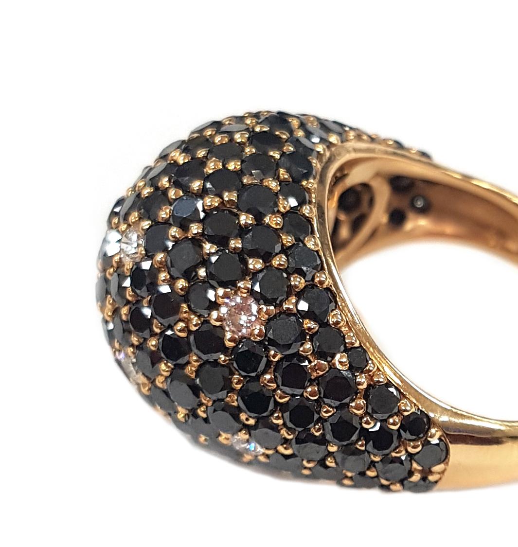 This sleek, Art Deco-inspired cocktail ring has been masterfully created entirely by hand from 18-karat rose gold and 200+ round black diamonds totalling 7.78 carats. Set throughout the black diamonds, 8 white diamonds glitter like stars in the