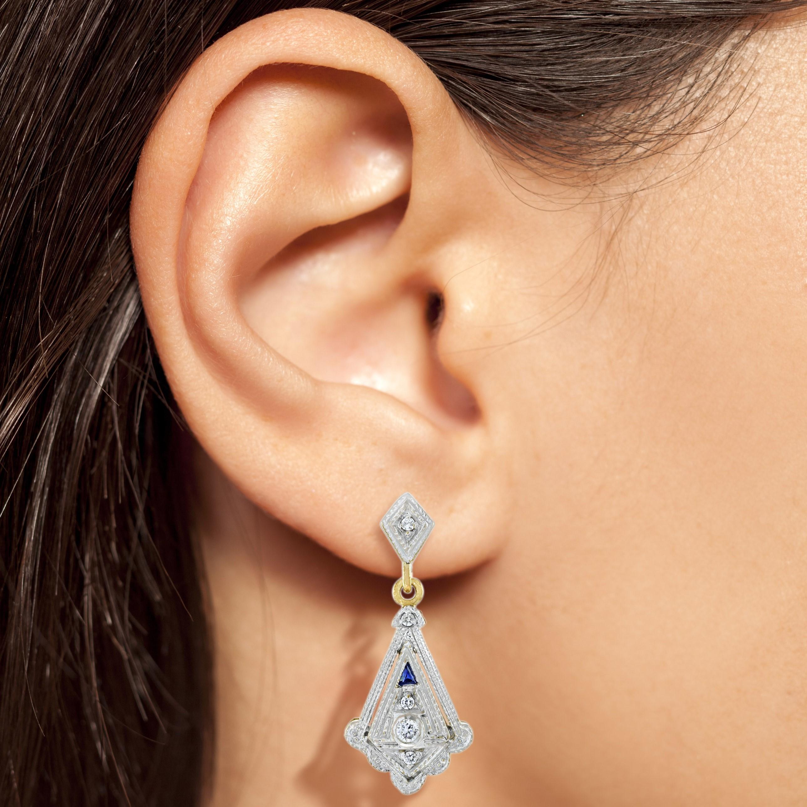 These lovely vintage style Art Deco diamond and sapphire earrings are hand crafted in 14k two tone gold setting. Angular diamond set teardrop shapes  dangle from the diamond ear posts, with 0.36 carats total of shimmering round brilliant cut