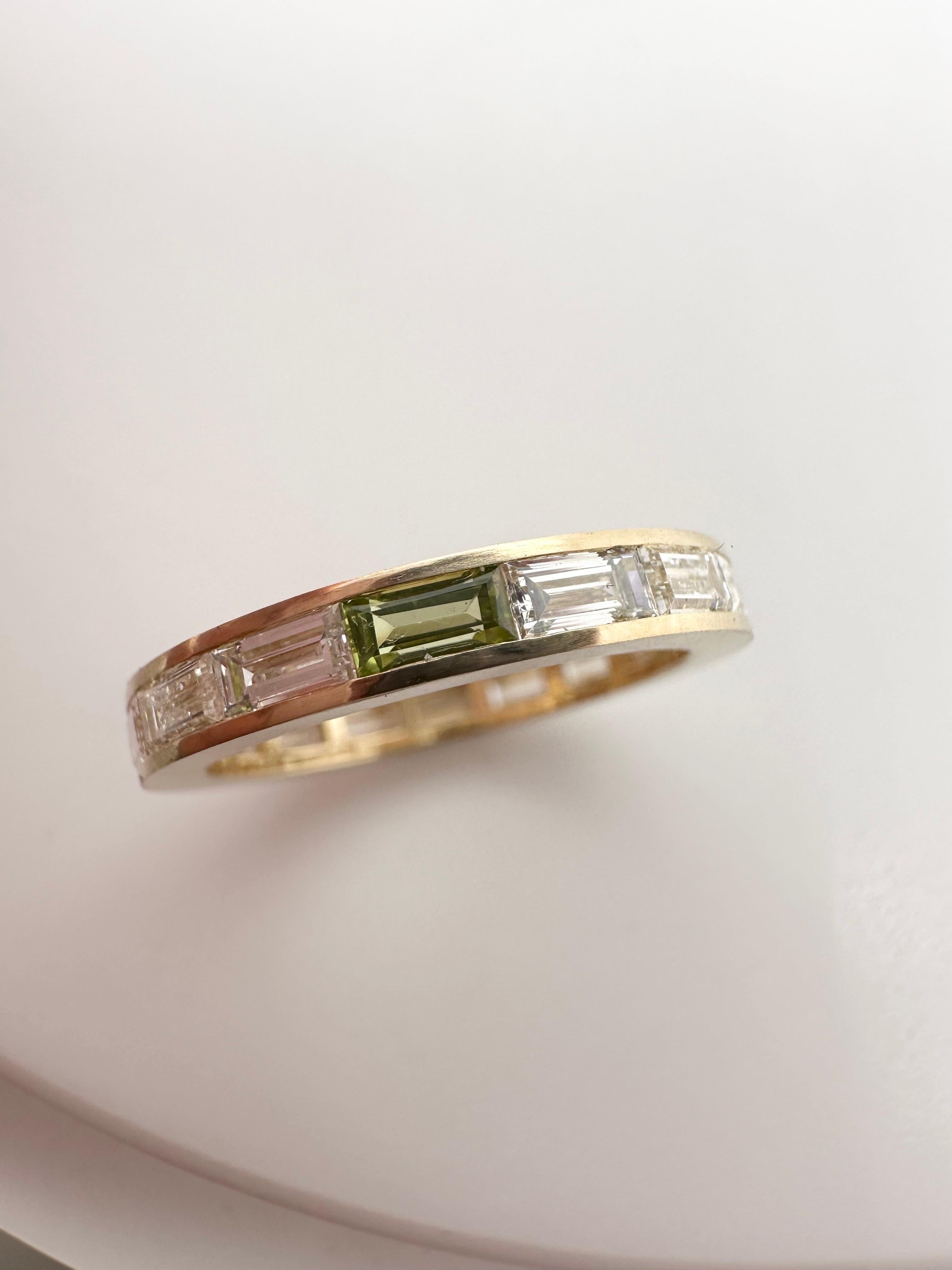 In style now, we see these rings everywhere! 
Wowser! Set all around with diamond baguettes except for one stone being a green peridot, this makes a difference and sets such a playful tone to the ring, made in 18KT yellow gold! In fashion now and