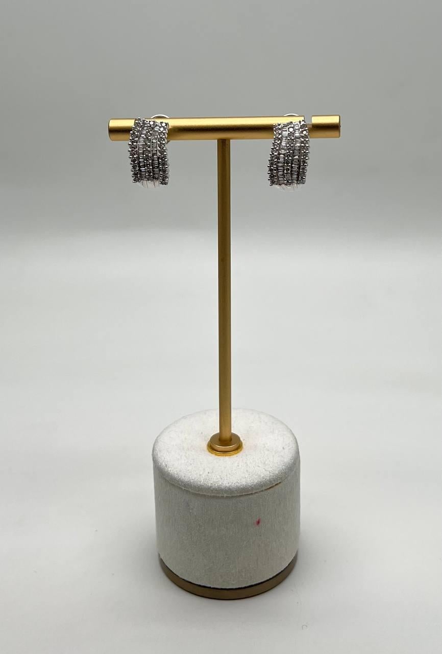 Questi squisiti orecchini presentano un design a strati con più file di diamanti scintillanti, creando un aspetto strutturato e lussuoso. Realizzati con precisione, presentano un'estetica moderna. Gli orecchini sono in ottime condizioni e offrono