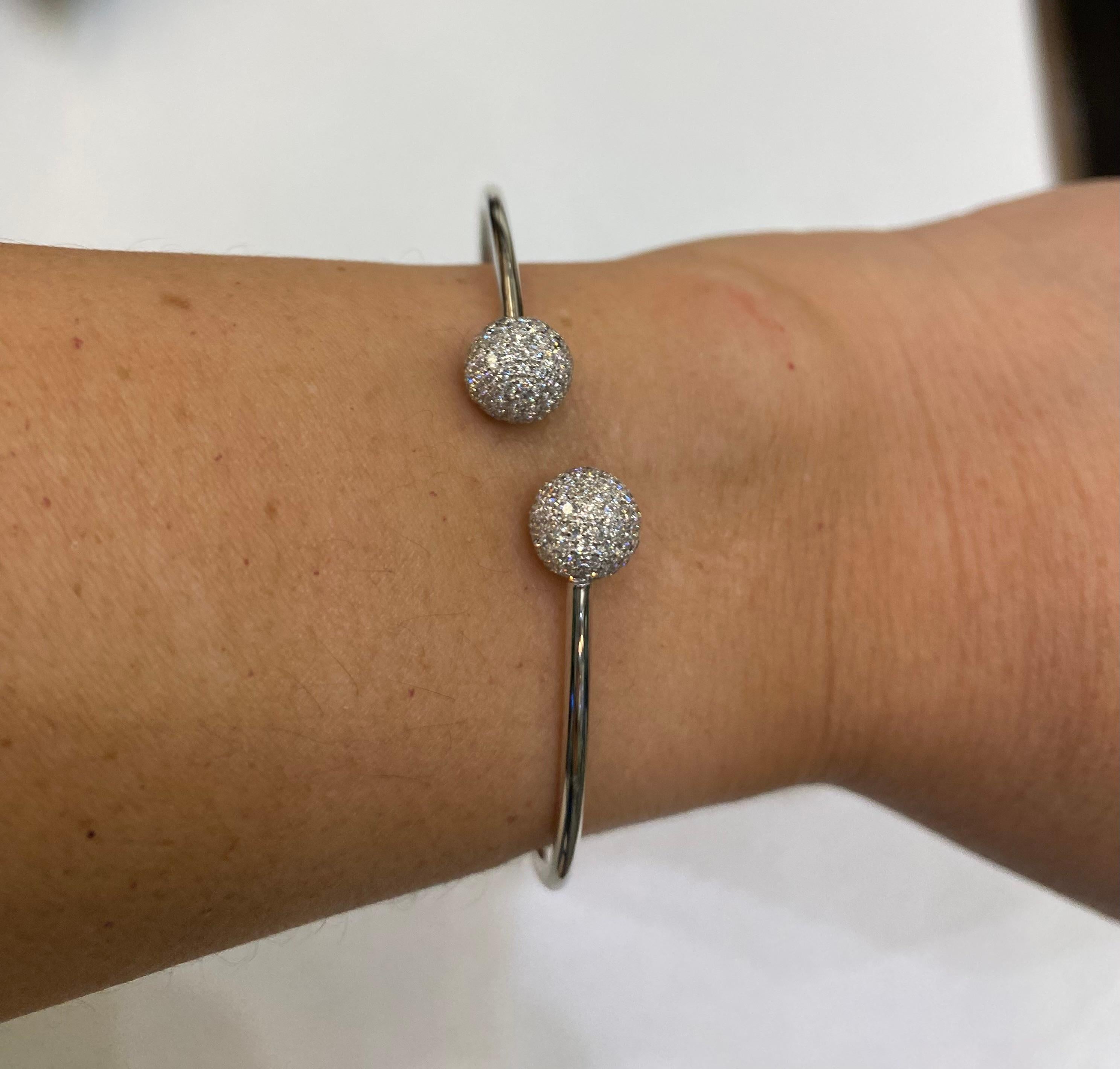 A diamond ball bangle bracelet in 18 karat white gold with 1.80 carats of diamonds.
This bracelet features a bangle-style design, which means it's a rigid bracelet without a clasp, meant to slip over the wrist. The 
