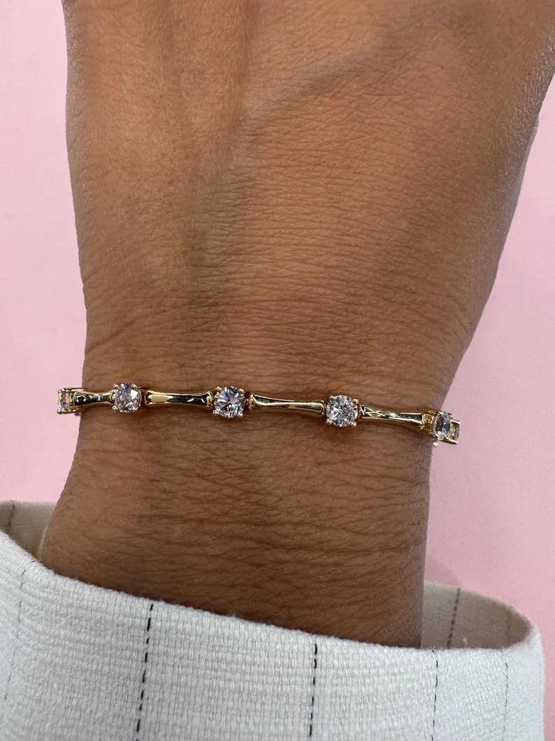 14 Karat yellow gold link bracelet featuring 14 round brilliants weighing 2.52 carats with a bamboo link in between each diamond.

More diamond bracelets in stock.
Message for pictures and information. 