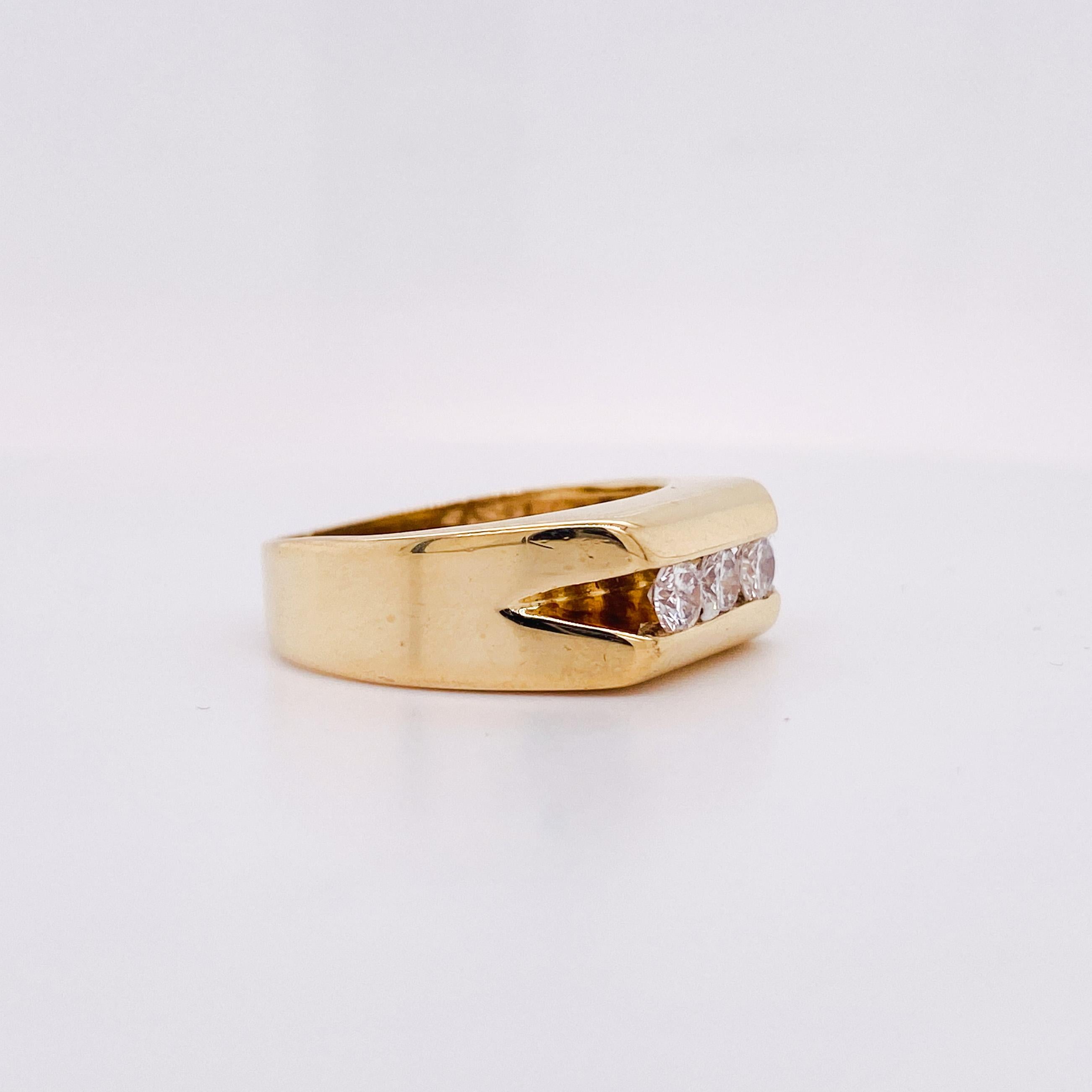 Three diamonds are presented in a secure channel on this beautifully heavy weight 14 karat yellow gold ring! This handsome ring is perfect for a wedding ring or a right hand ring. The channel holding the diamonds is deep and brightly polished