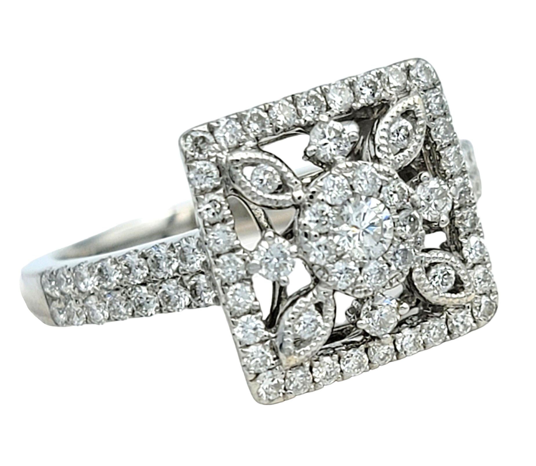 Ring Size: 6.5

This diamond cocktail ring is a captivating piece set in 18 karat white gold. Its centerpiece features a unique square cut-out design, adding an element of intrigue and modernity to the ring. Encrusted with dazzling diamonds along
