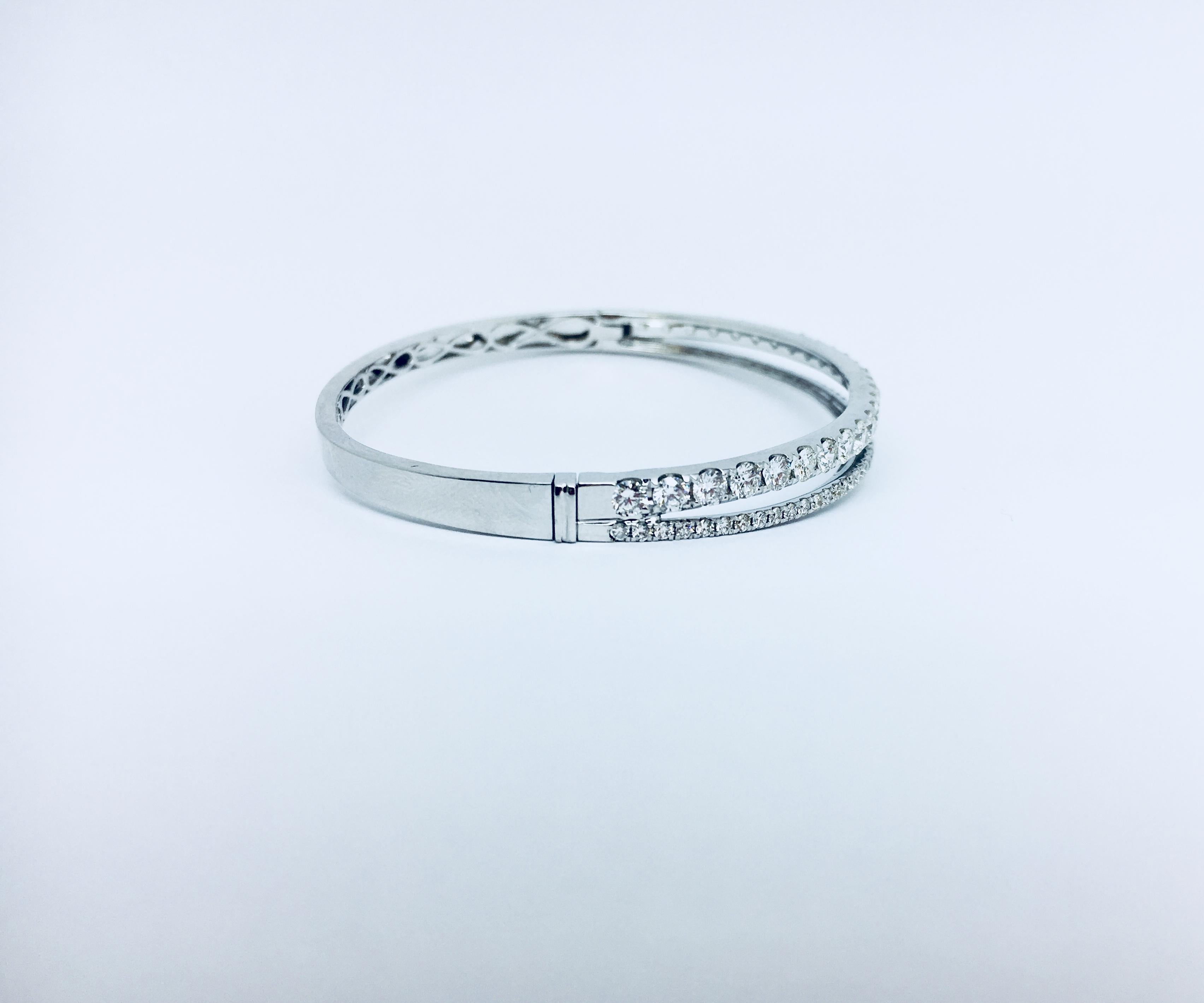 Diamond bangle double row of diamonds in 18kt white gold. This bracelet contains 78 round brilliant diamonds that total approximately 3.04 carats of diamonds. The bangle itself weighs 13.8 grams and would look great styled on it's own or paired with