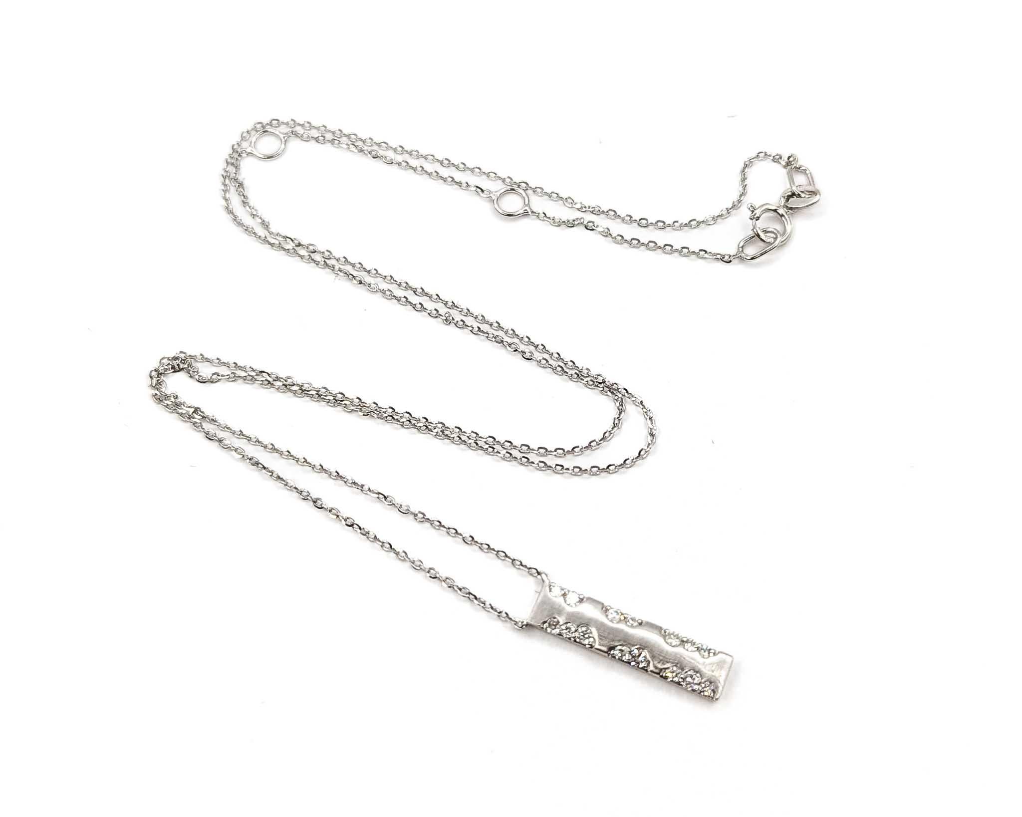 This necklace is crafted in 14k white gold and features diamond, with a bar design. The round diamonds total 0.20ctw, near colorless with SI to I clarity.

The necklace measures approximately 15.5–16.5 inches. Additional dimensions measures