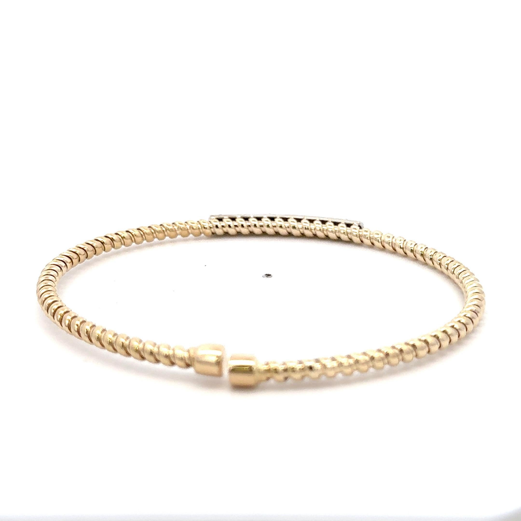 Italian 14 karat yellow gold twist bangle bracelet with a diamond bar containing 42 round brilliants weighing 0.38 carats.
Color F
Clarity VS1-VS2