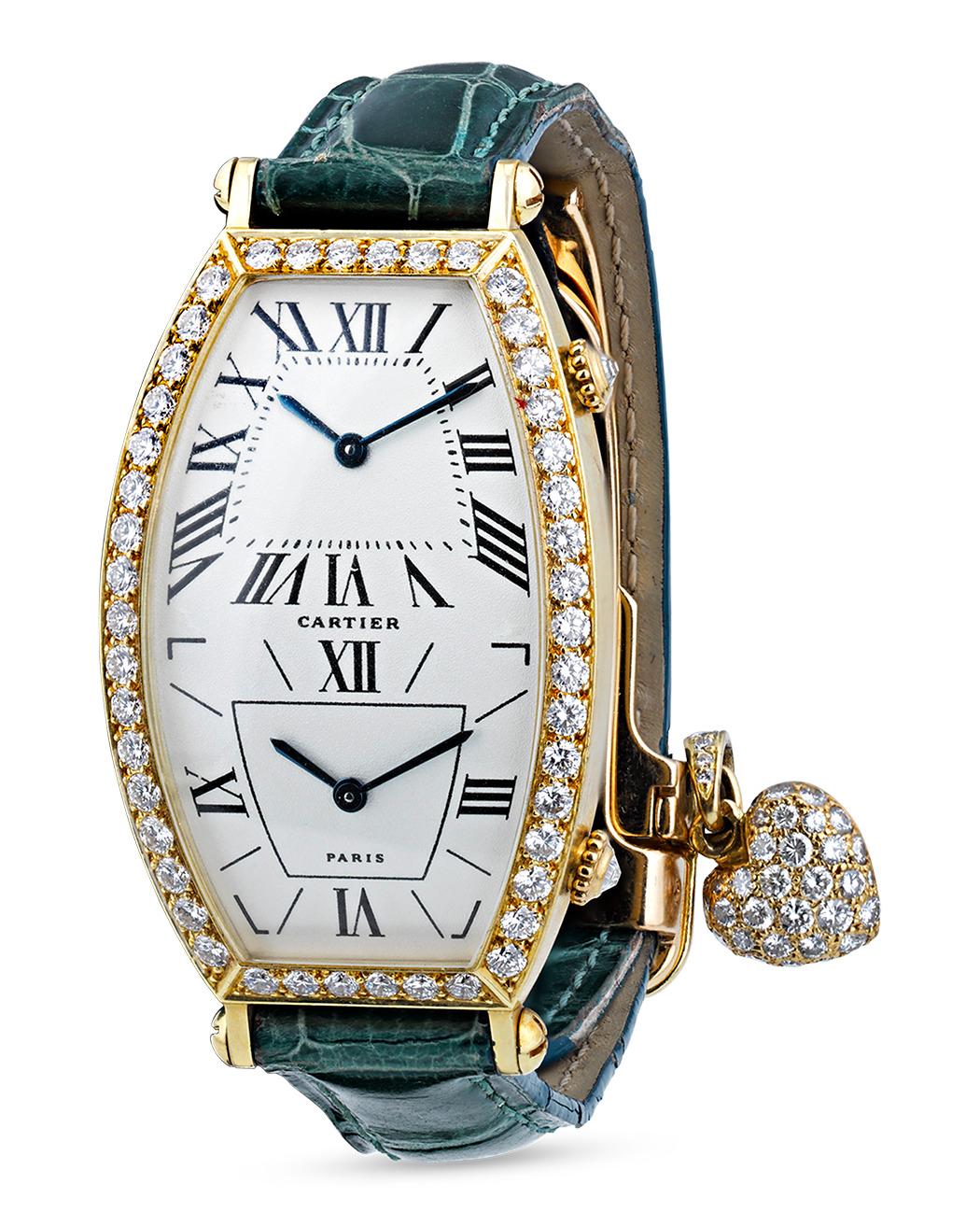 This stylish dual time tonneau wristwatch exemplifies the timeless artistry of Cartier’s legacy. The sleek design exhibits an 18K white gold tonneau case with brilliant factory-set diamonds emblazoning the bezel and crown. The elongated dial
