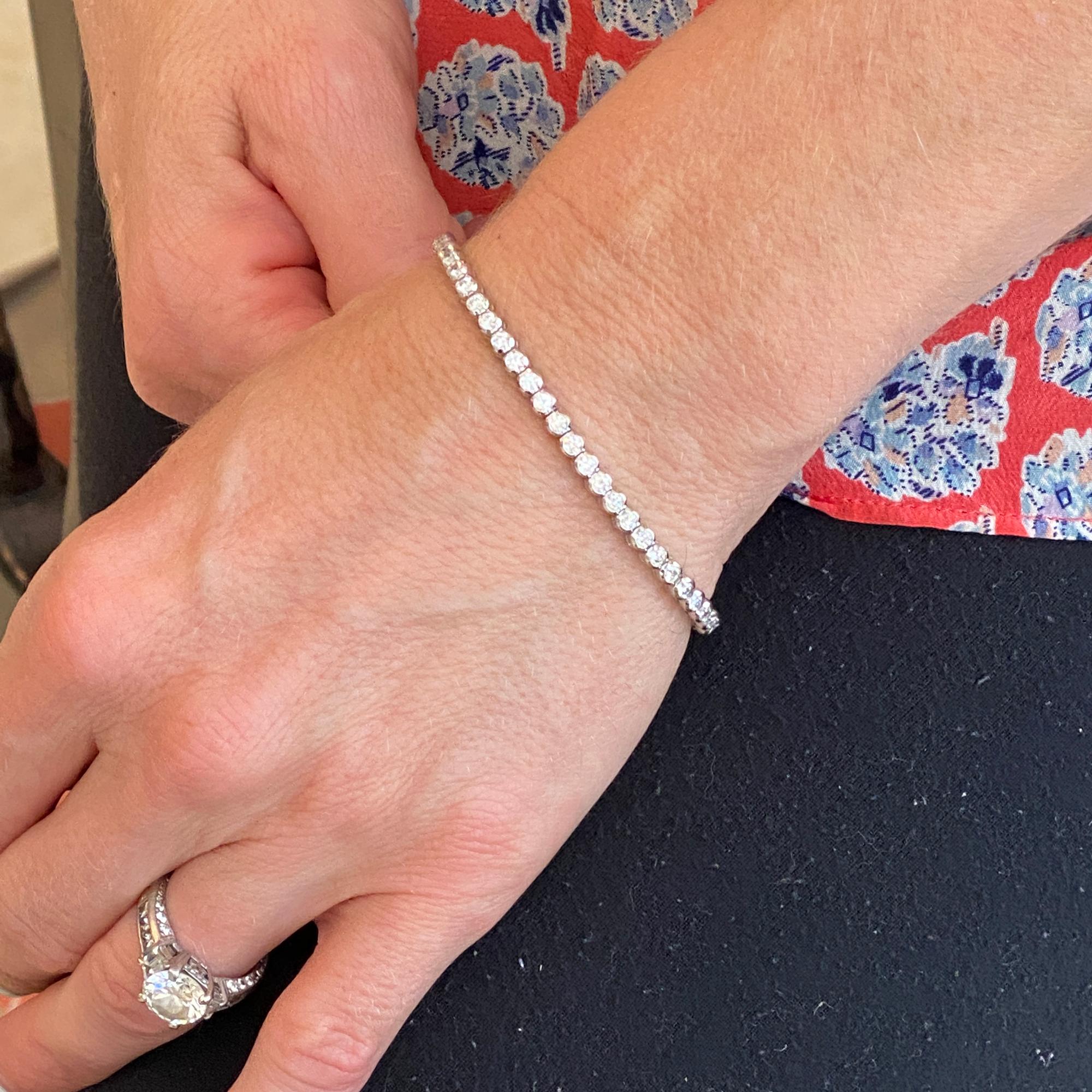 Diamond bezel set tennis bracelet fashioned in 14 karat white gold. The bracelet features 63 round brilliant cut diamonds weighing 3.42 carat total weight. The bezel set diamonds are graded G-H color and VS clarity. The bracelet measures 7.5 inches