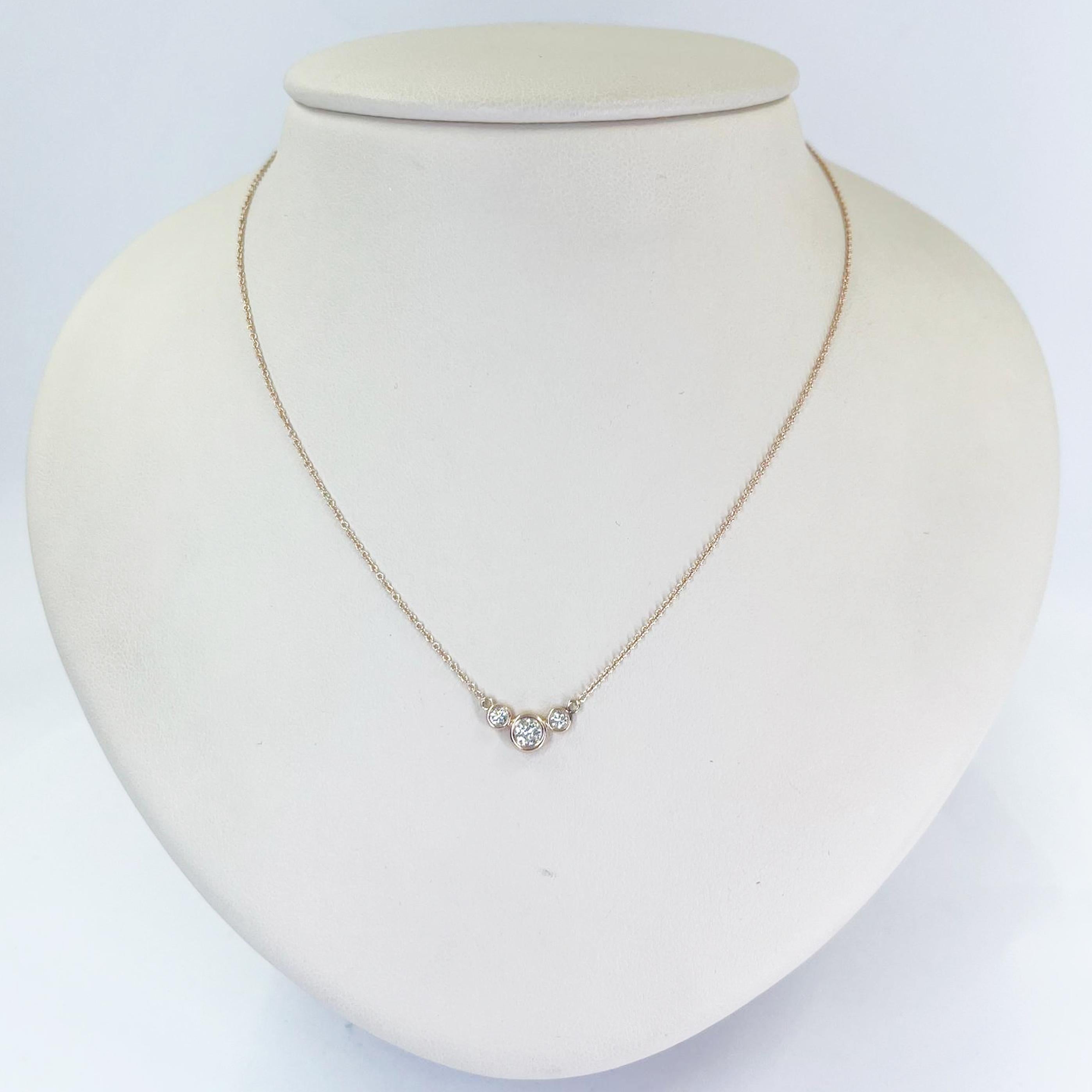 14 karat rose gold necklace featuring 3 round brilliant cut diamonds of VS clarity and H color totaling 0.25 carats. 16 inch chain with spring ring clasp. Finished weight is 1.6 grams.