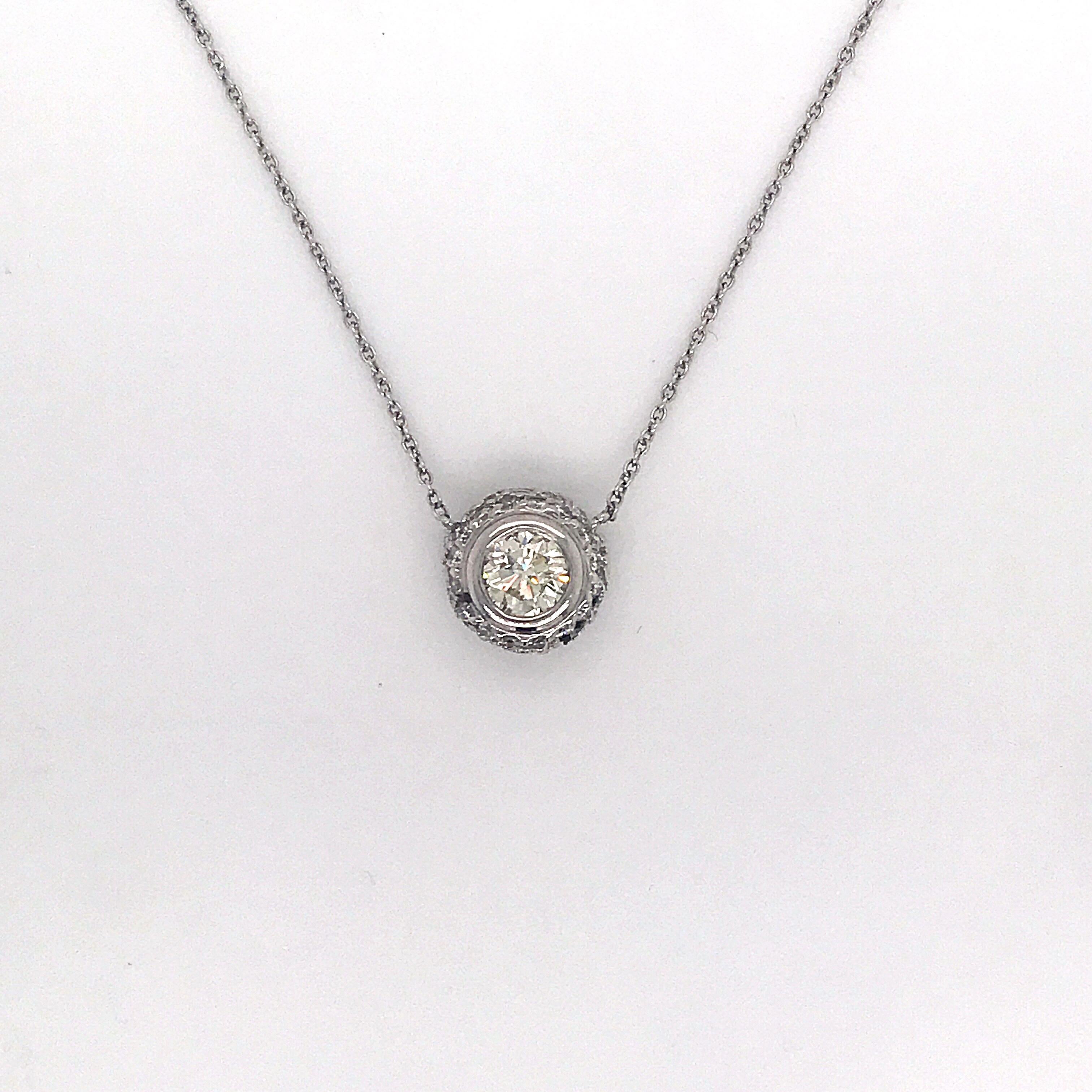 Diamond pendant necklace featuring one round brilliant flanked with numerous diamonds weighing 1.36 carats, in 14k white gold. 
Color: J
Clarity: SI1