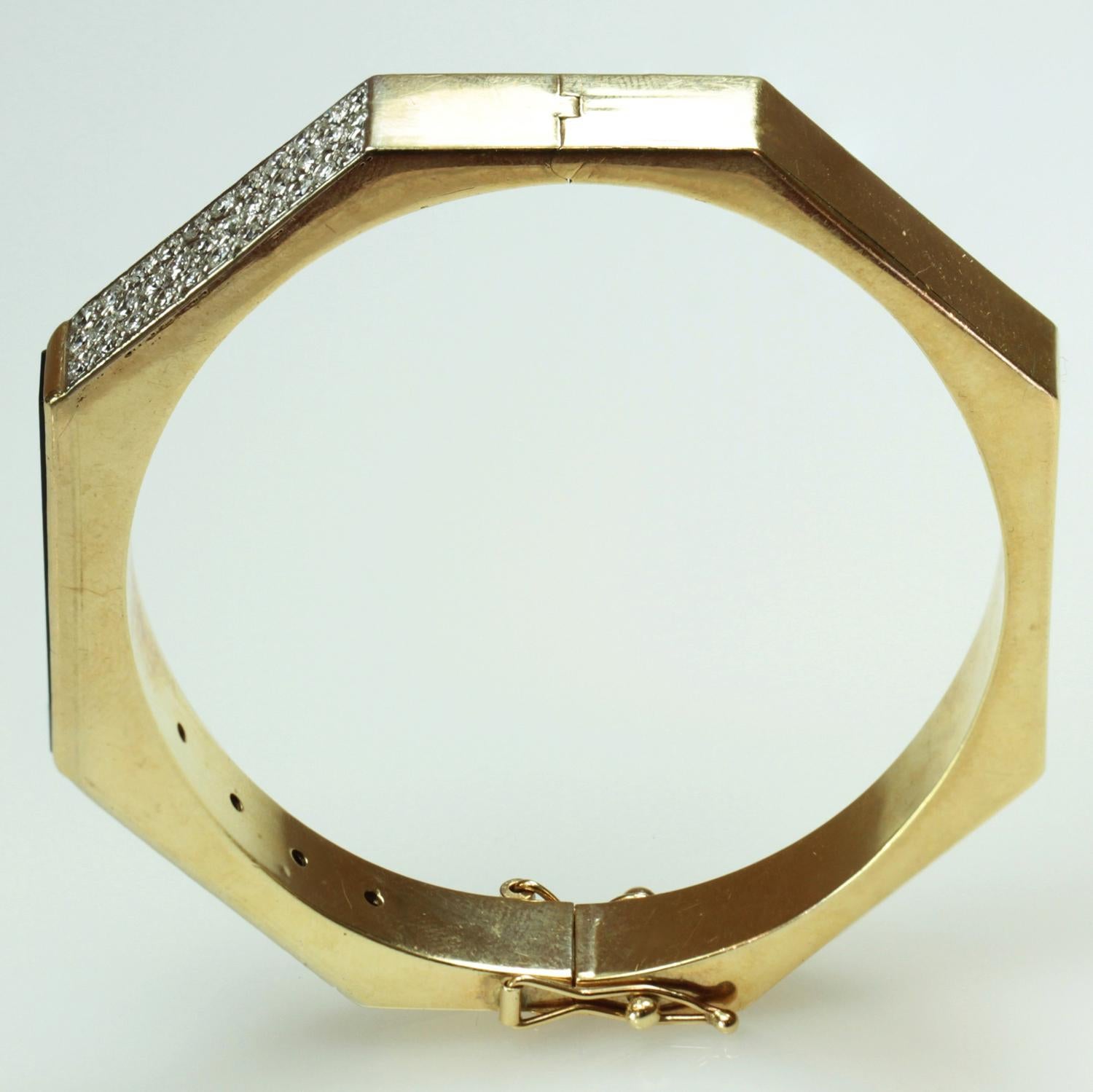 An estate hexagon bangle made in 14k yellow gold and featuring rectangular black onyx inlays and 68 pave-set round diamonds. The bracelet is completed by 2 safety catches. A very stylish design. Measurements: 0.27