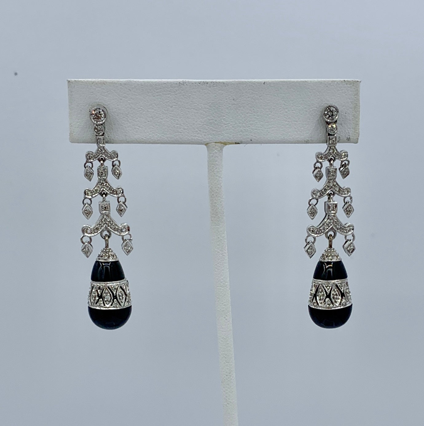 This is a magnificent pair of Diamond and Black Onyx 18 Karat White Gold Dangle Drop Earrings of a stunning two inches in length.  These beautiful dangle drop earrings are fully articulate throughout.  At the base is a spectacular pear shape Black