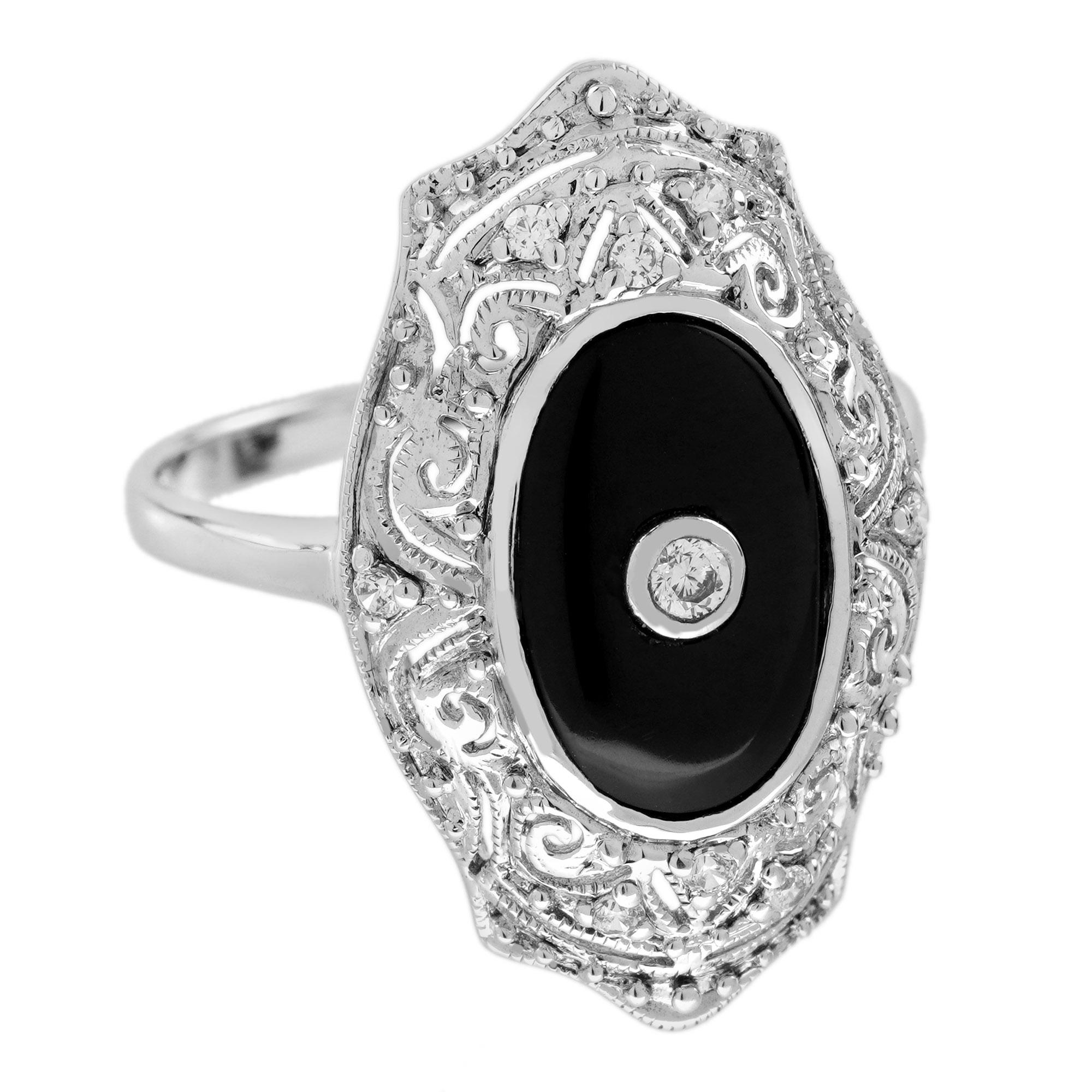 Con un elegante engaste de filigrana, un centro de ónix negro se eleva en este precioso anillo Art Decó de oro blanco. El ónice de forma ovalada está bellamente adornado con un diamante que brilla desde un engaste con borde milgrain, acentuado por