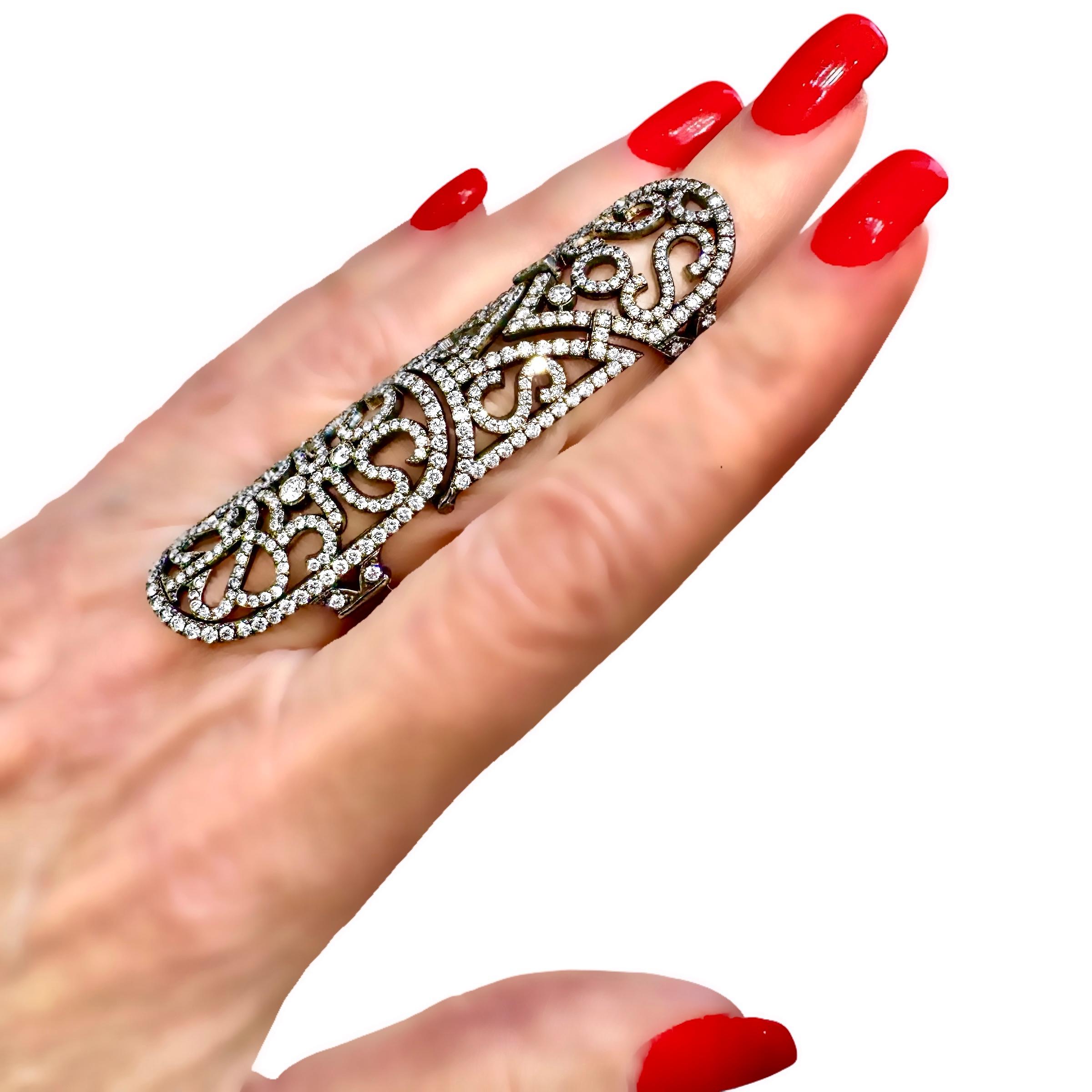 This powerful black plated, 18K white gold and diamond full finger ring, imagined and created by famed jewelry designer Jacob Arabov, founder and director of Jacob & Co., measures a full 2 5/16 inches long. It is made in two pieces that are hinged