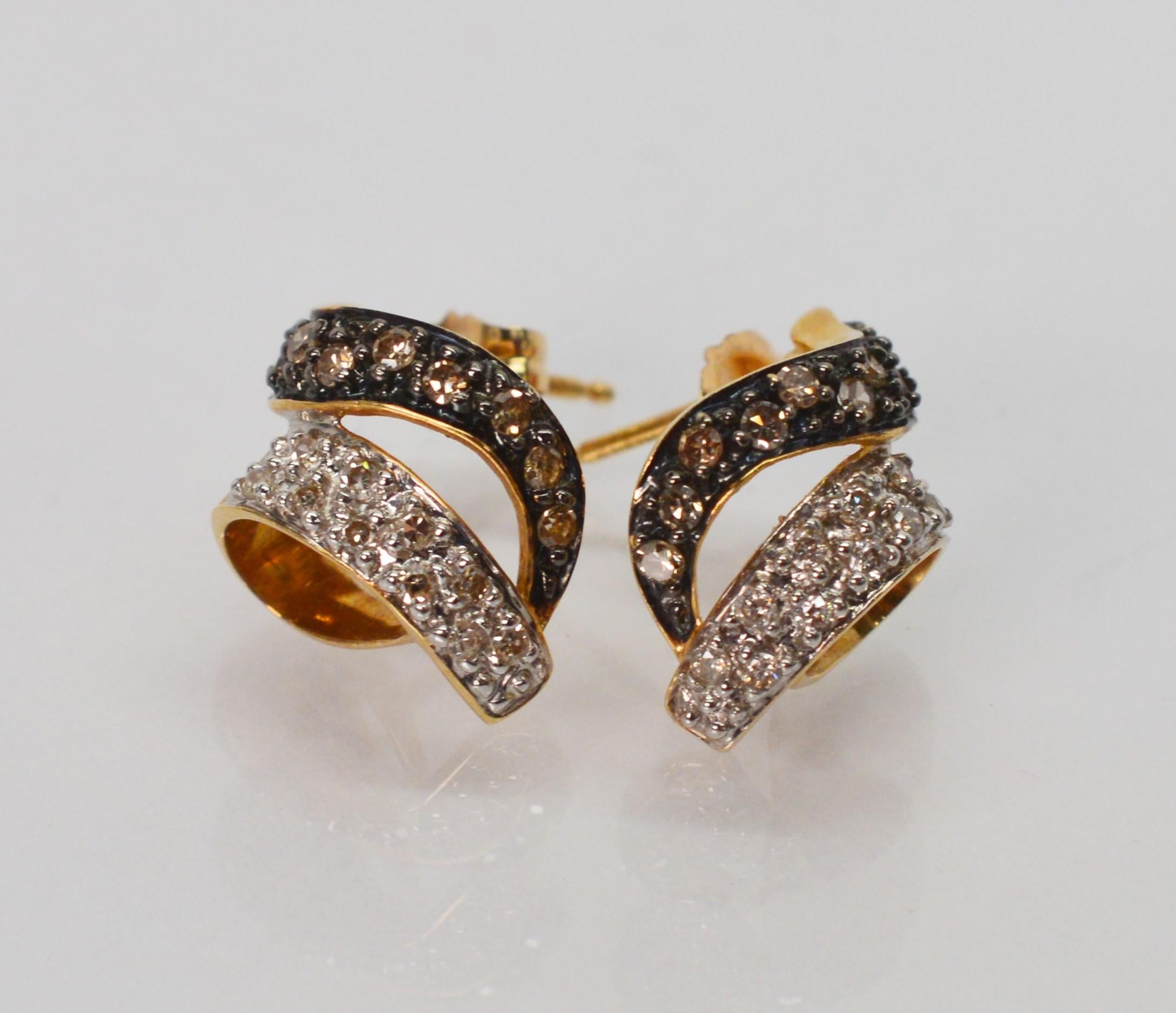 Classic in style, always with big impact. A swirling ribbon of fourteen karat yellow gold accented with black enamel and white diamonds give this earring pair true flair. The pairing of black and white ensures versatility for all occasions.