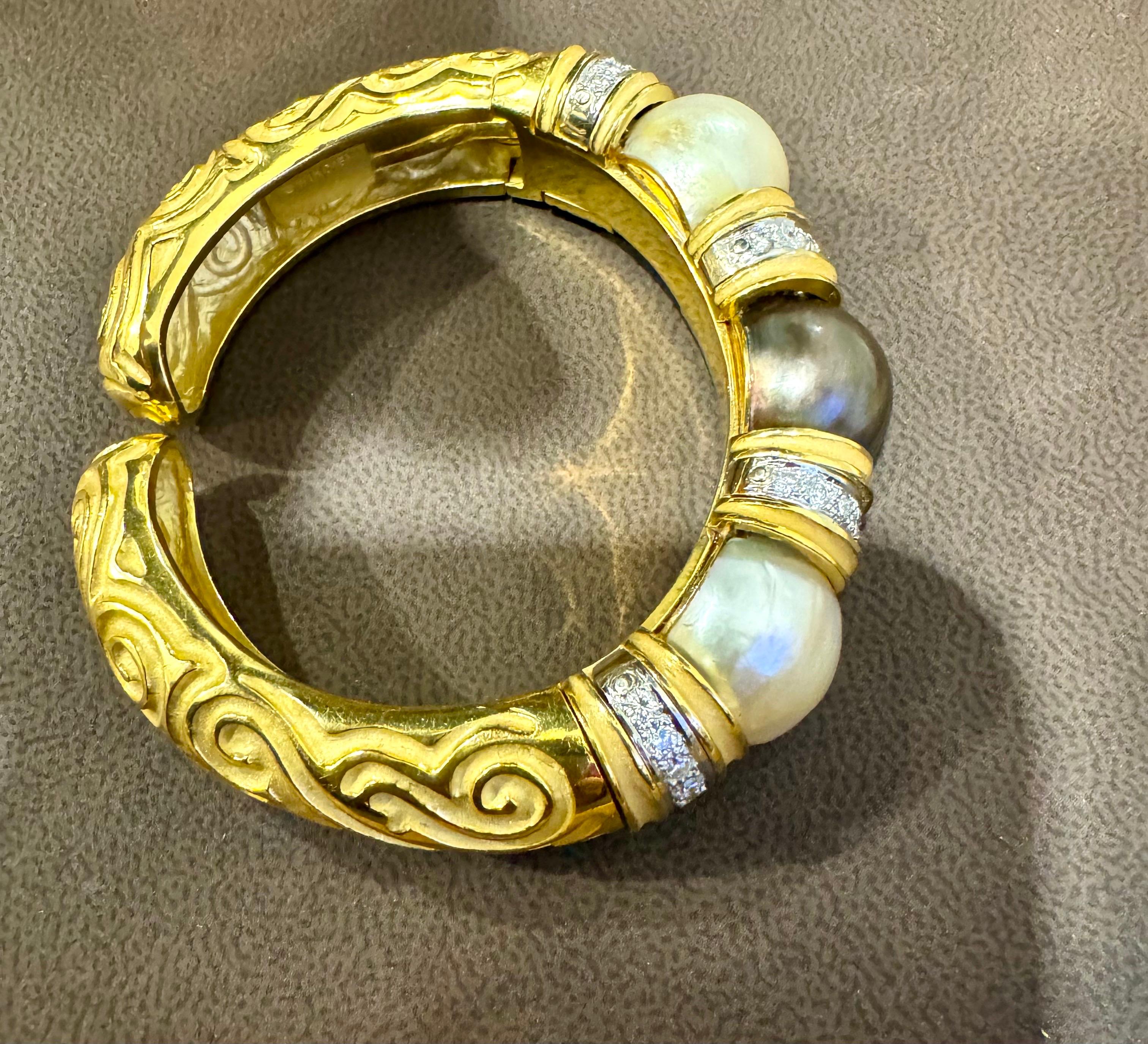 Un braccialetto del designer Robert Wander Winc
Nome del progettista  e 18 K è inciso sul braccialetto.
Diamante  con una perla nera e due perle bianche Mabe Bracciale Bangle in oro giallo 18 carati 115 grammi
Il braccialetto è realizzato con un