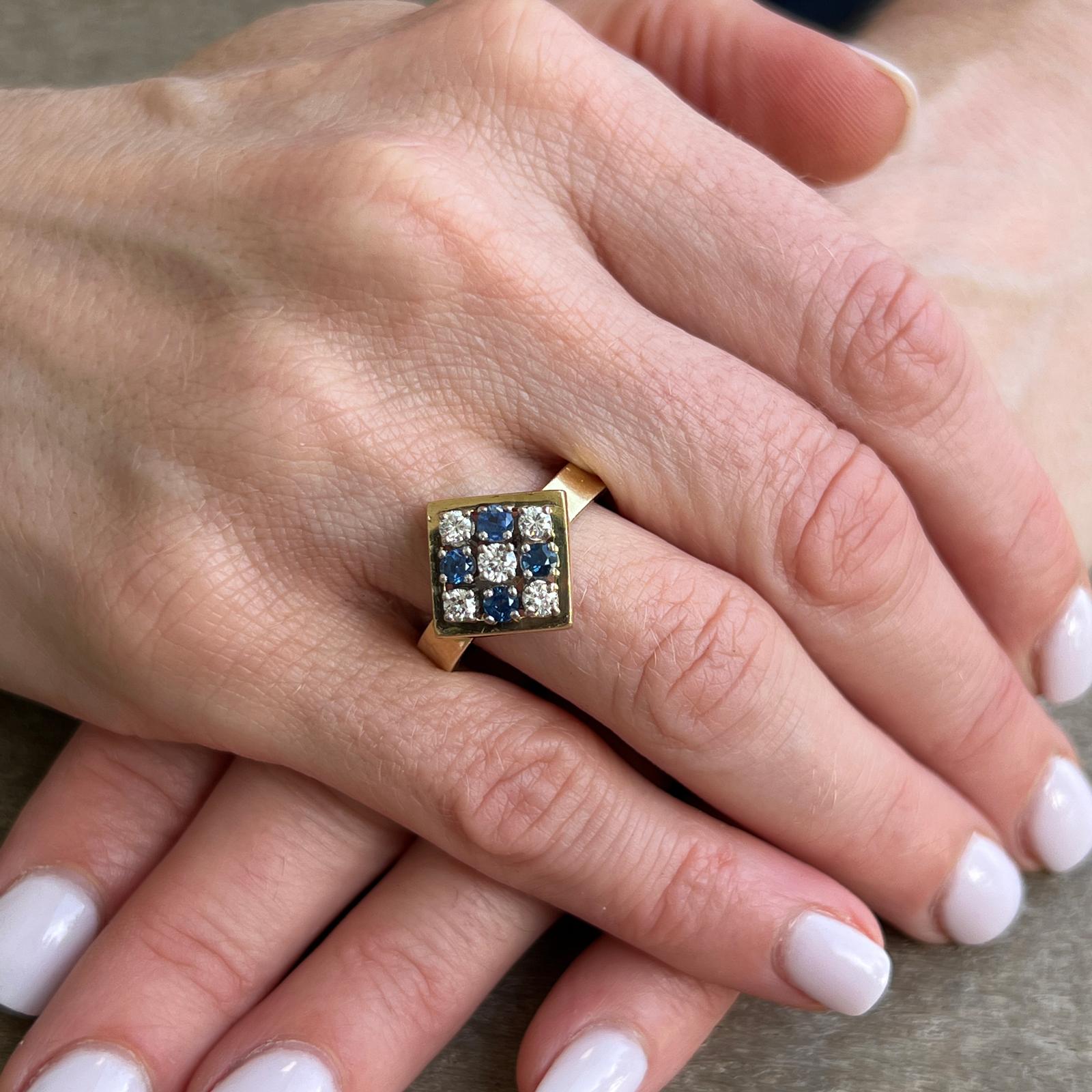 Fabulous checkerboard sapphire diamond vintage ring crafted in 18 karat yellow gold. The ring features 5 round brilliant cut diamods and 4 round natural blue sapphires. The diamonds weigh approximately .35 CTW and are graded I color and VS clarity.