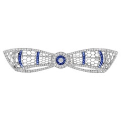 Spilla con diamante e zaffiro blu in stile Art Deco con arco e corona in oro bianco 14 carati
