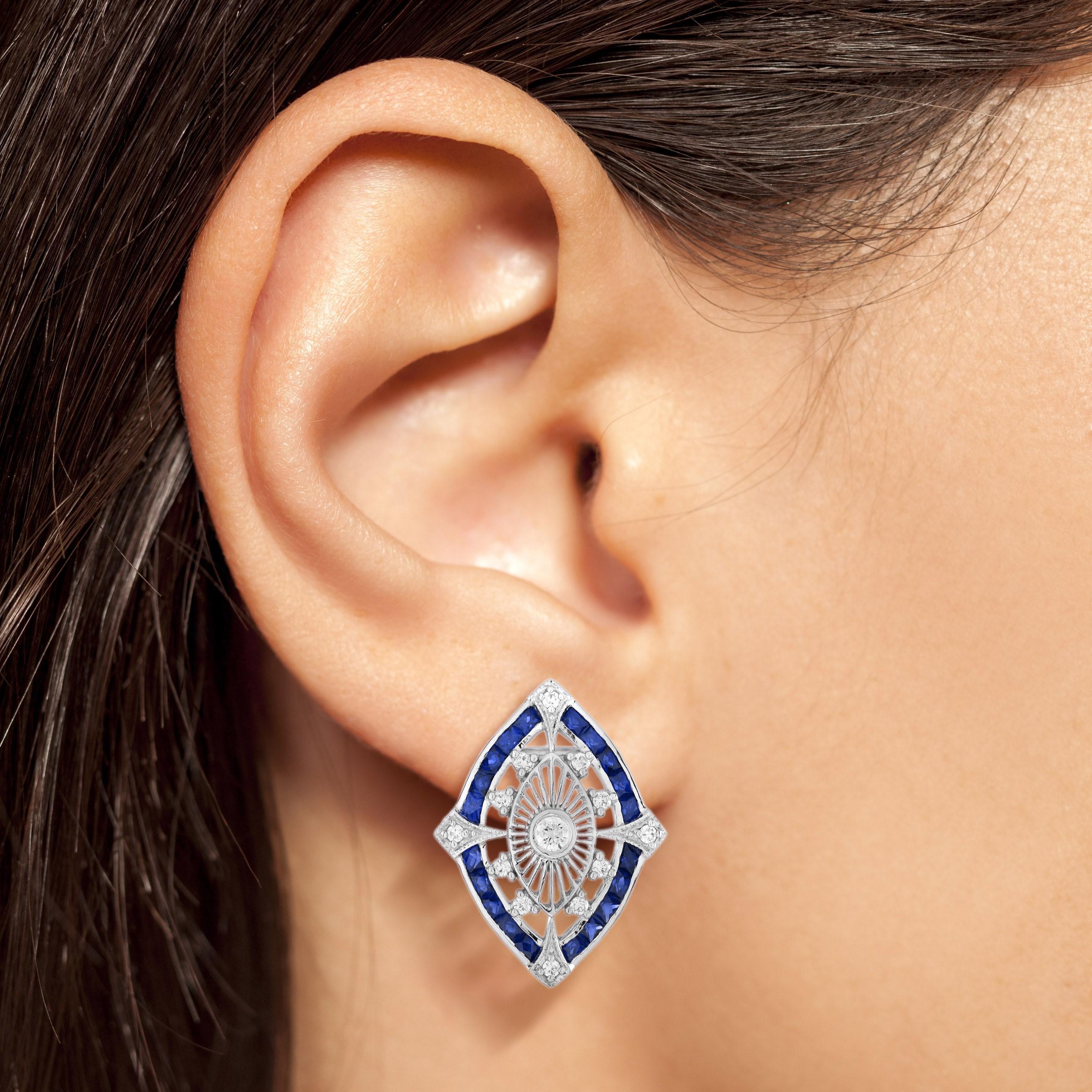 Step into the glamour of the Art Deco era with these exquisite stud earrings. Featuring dazzling diamonds and deep blue sapphires, their symmetrical design captures timeless elegance and sophistication. Crafted in lustrous 14K white gold, these