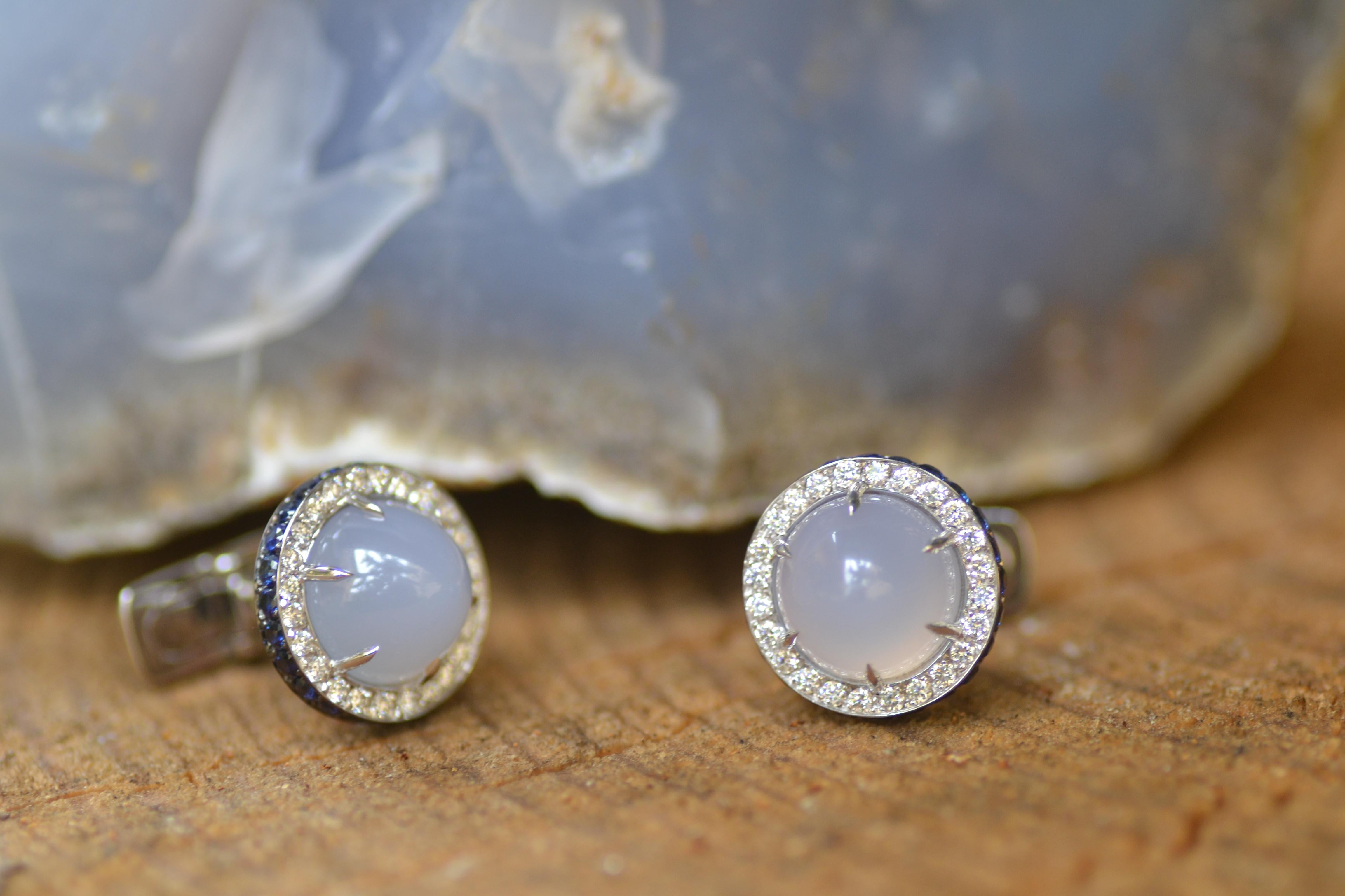 Handcrafted in Margherita Burgener workshop, Italy, the pair of cufflinks feature as central stone a cabochon chalcedony surrounded by a line of colorless diamonds.
A lateral  line of blue sapphires enhance the elegance of these cufflinks. 
T bar is