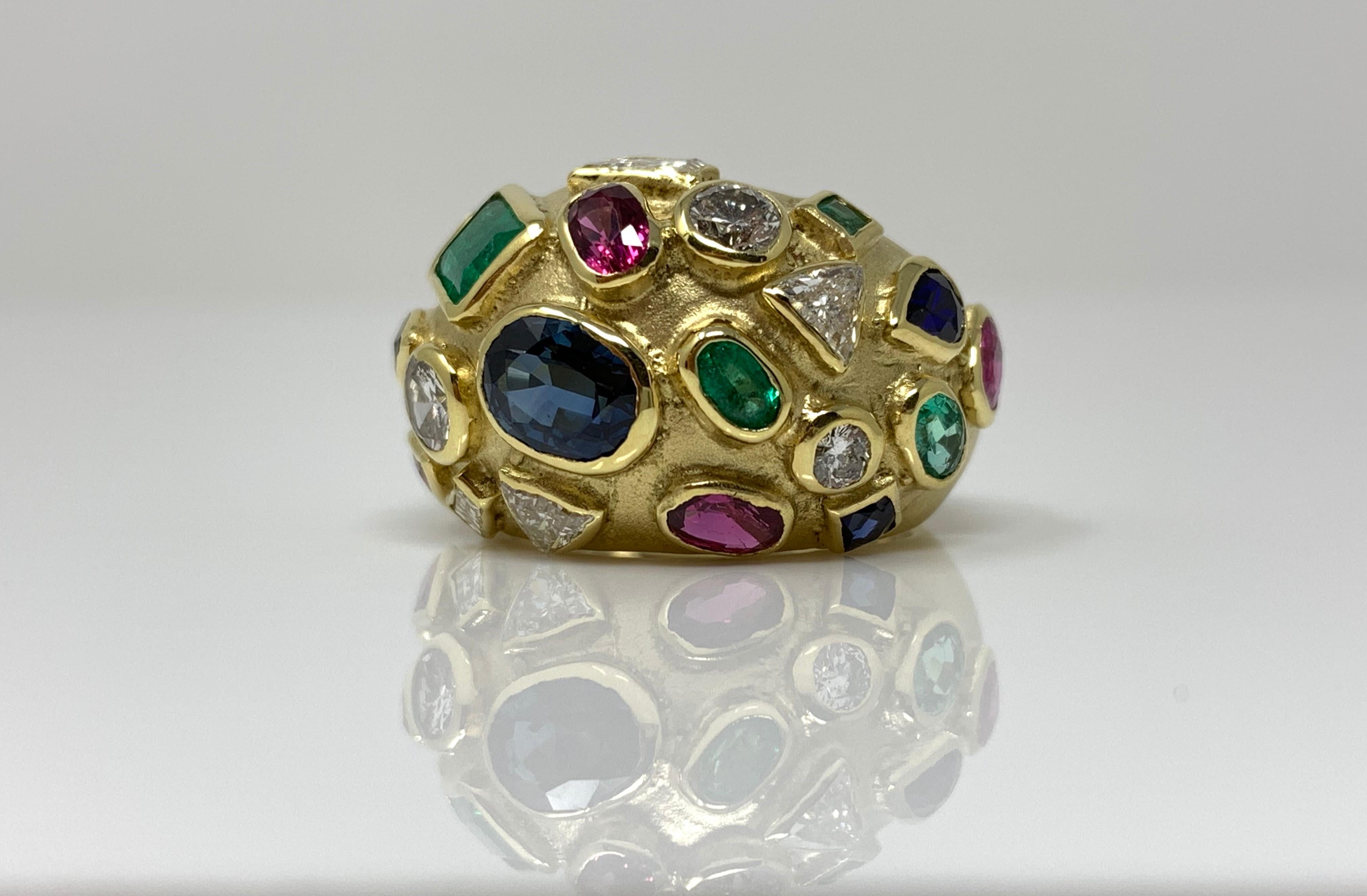 This bold, beautiful and unique ring is wonderfully hand crafted in 18 k yellow gold. 
The gorgeous ring is bezel set with multicolor precious stones like ruby , emerald , blue sapphire and diamond in 18k yellow gold. 
Diamond weight : 0.85 carat