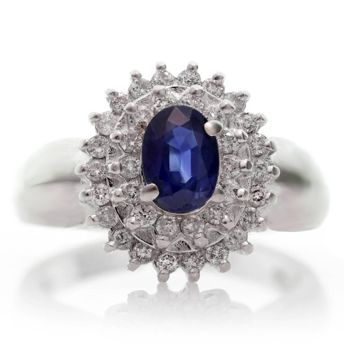 This majestic dome-shaped vintage ring is made in 14k white gold and features a vivid blue 5.0mm x 7.0mm faceted oval sapphire in the center 0.85ct., surrounded by an estimated 0.70 carats of sparkling diamonds. Circa 1980s. Measurements: 0.55