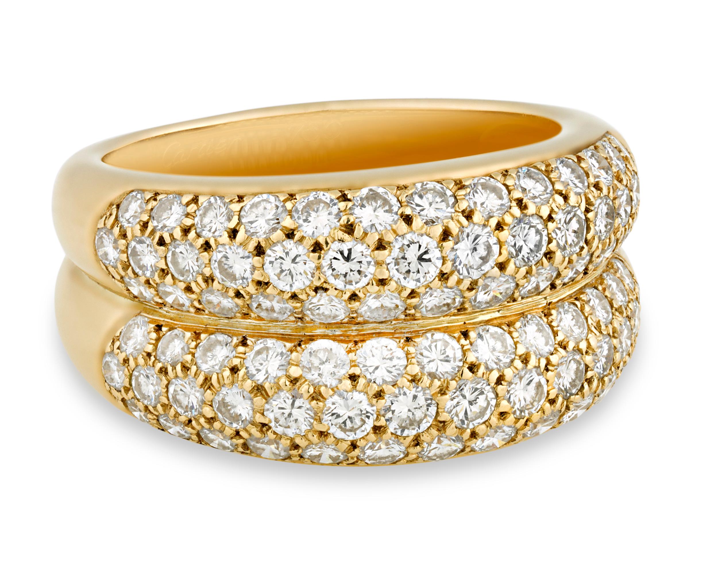 Two rows of brilliant pavé-set diamonds totaling approximately 2.50 carats form this dramatic bombe-style ring by the legendary Cartier. Combining exquisite gems and daring design, this 18K yellow gold ring is a standout example of retro cocktail