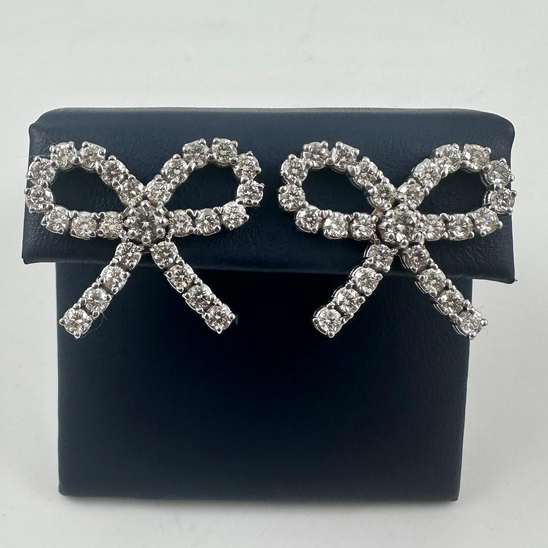 Feminine Eleganz trifft auf schillernde Brillanz in diesen exquisiten diamantenen Ohrsteckern mit Schleife, die wunderschön aus 14 Karat Weißgold gefertigt sind. Diese Ohrringe in verspielter und doch raffinierter Bogen-Silhouette sind mit