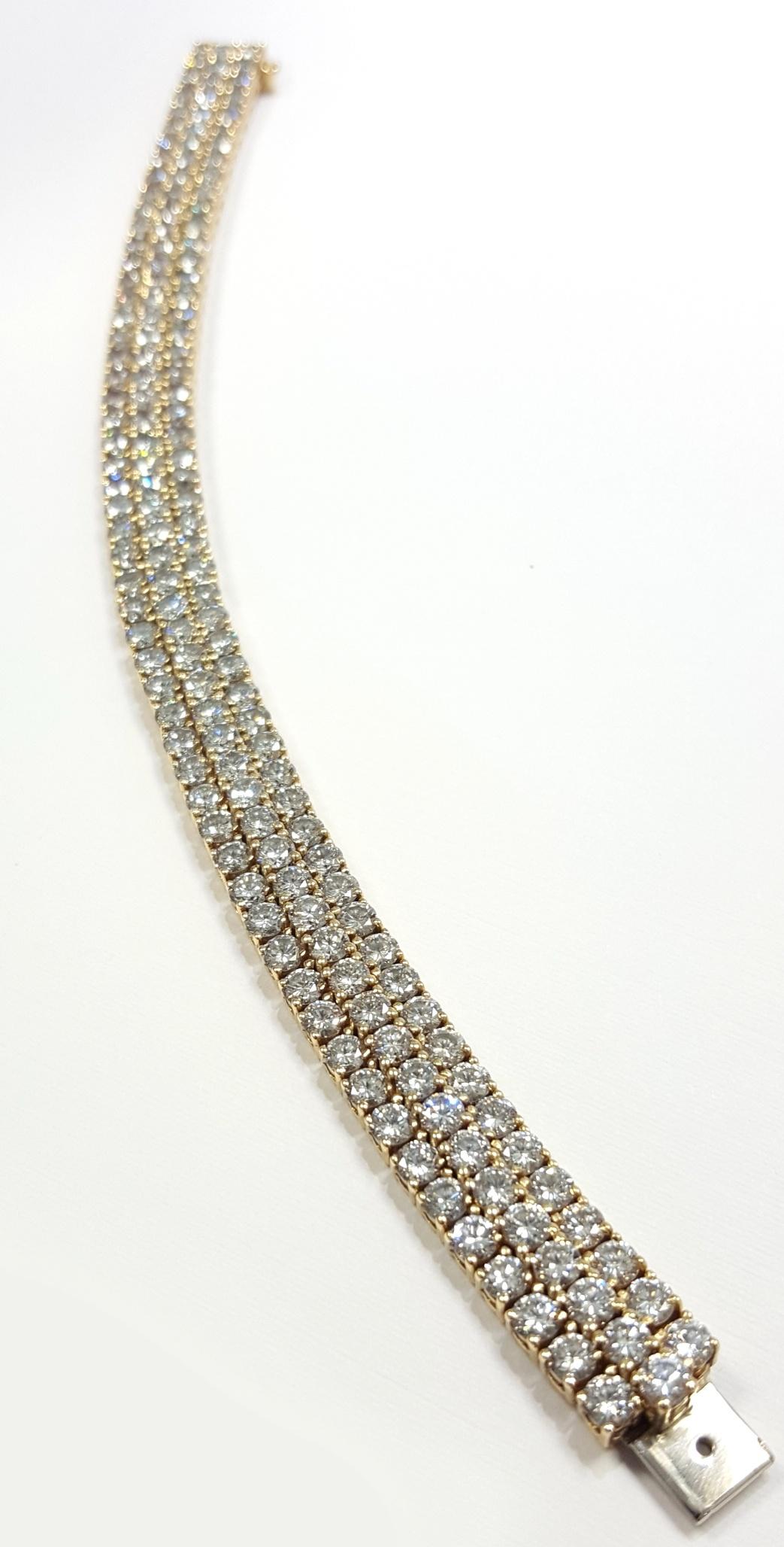 An expertly made yellow gold bracelet. There are 162 Round Brilliant cut diamonds that are G to H color VS1 to VS2 clarity. The diamonds are set in 3 rows and are set in four prong basket style settings. The bracelet measures 6 and 7/8 inches long