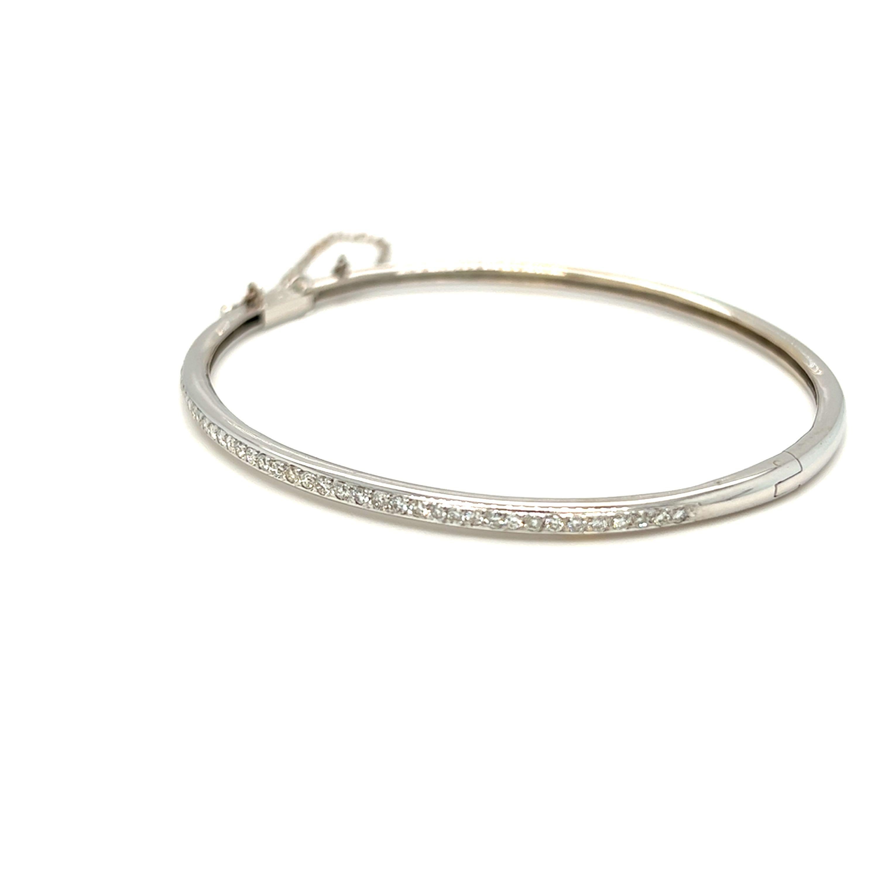 A classic wardrobe staple, perfect for every occasion. This bangle features diamonds that float across the wrist in a delicate shared prong 14k white gold setting. Just perfect amount of sparkle to your bracelet stack. The clasp has a security chain