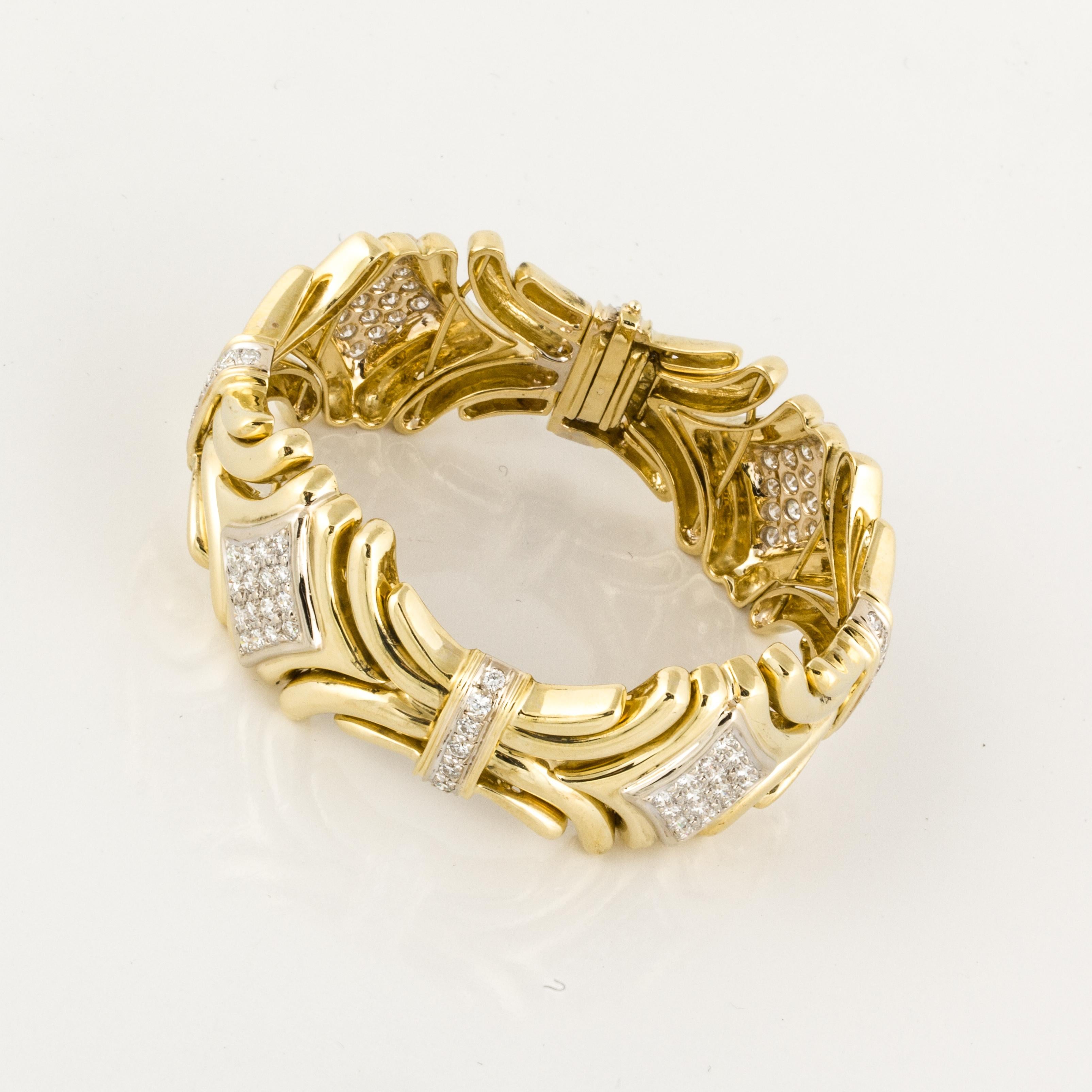 18K yellow gold wide bracelet with four diamond shaped stations and spacers with diamonds.  There are 92 round diamonds that total 4.90 carats, G-H color and VS1-SI1 clarity.  It measures 7 inches long and 1 inch wide.  