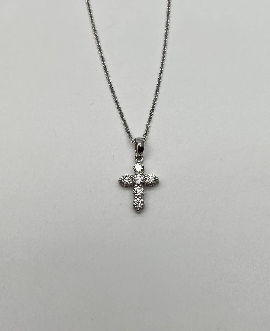 Una delicata collana con ciondolo e croce ornata da scintillanti diamanti bianchi brillanti. Il pezzo è elegantemente sospeso su una catena sottile, che mostra una meticolosa attenzione ai dettagli nel suo design. Oro bianco 14K. Diamanti 0,97 CTW.