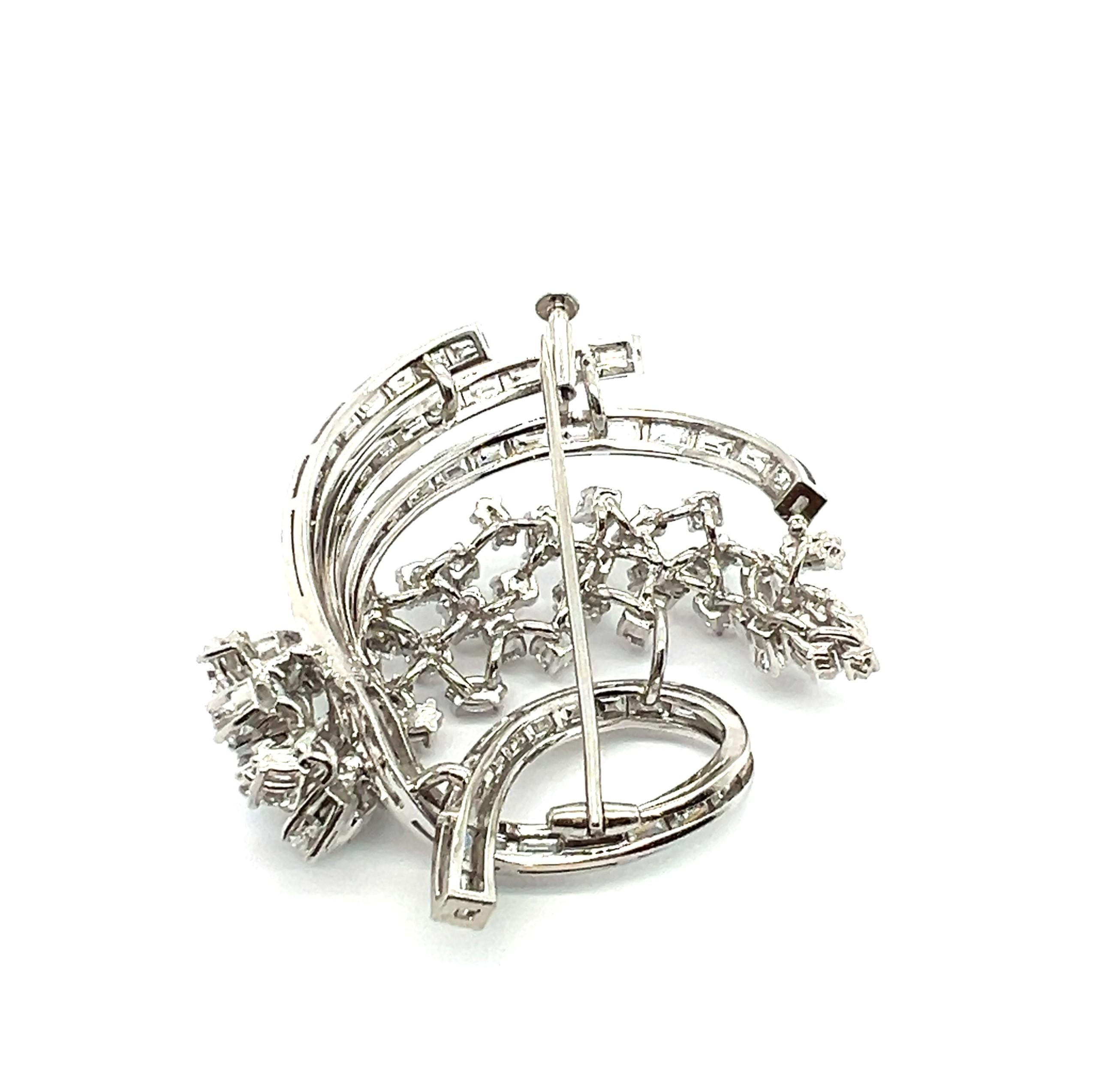 This brooch by Swiss House Bucherer is a stunning dance of elegance and precision.

A swirl of 55 baguette-cut diamonds, totaling 4.40 carats, forms the brooch's sleek base, casting sharp, dazzling flashes of light. Interwoven are 27 brilliant-cut