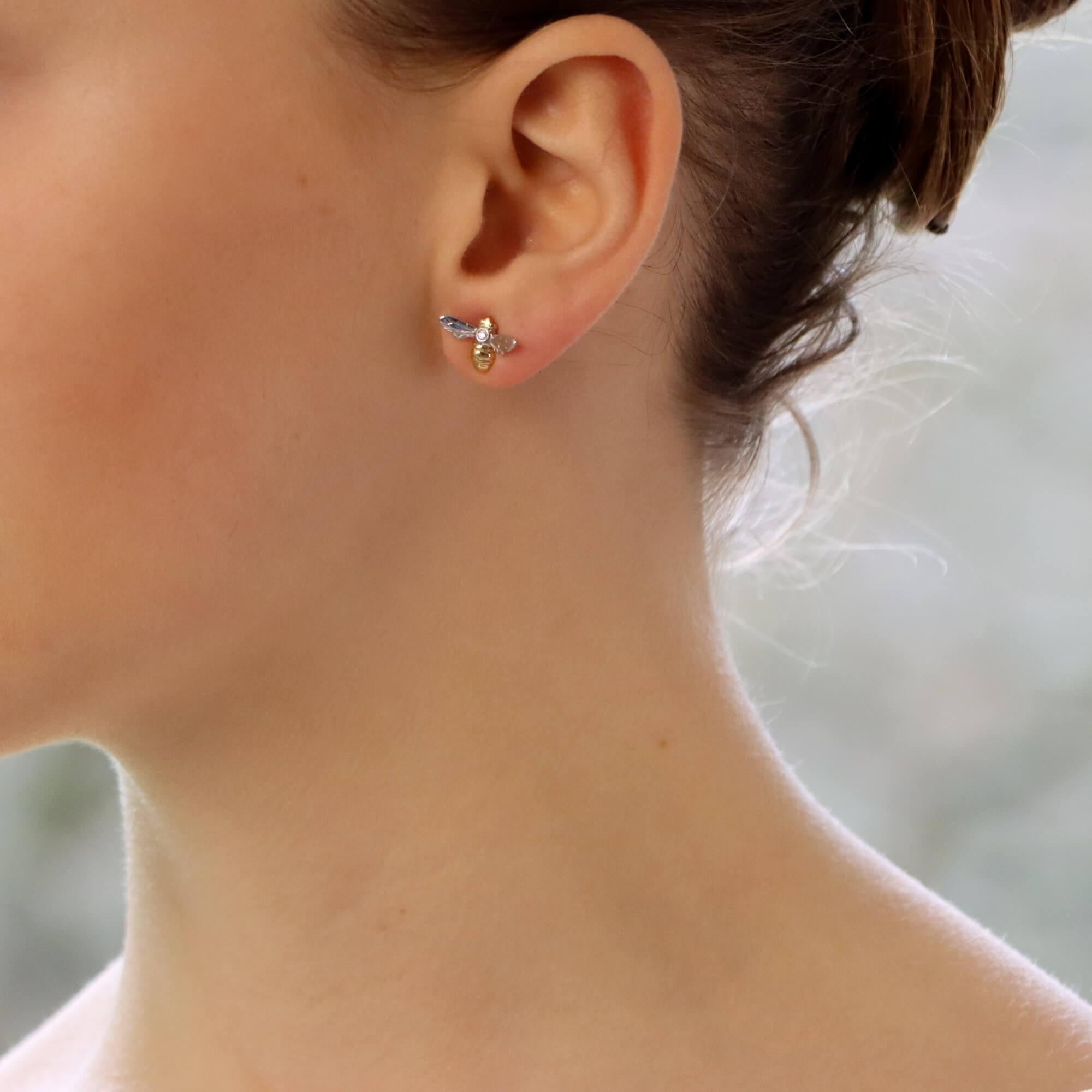 A beautiful pair of little diamond bee stud earrings set in 18k white and yellow gold. 

These adorable little bees are each accented to the centre with a small 0.03 carat round brilliant cut diamond. To either side of this diamond are two