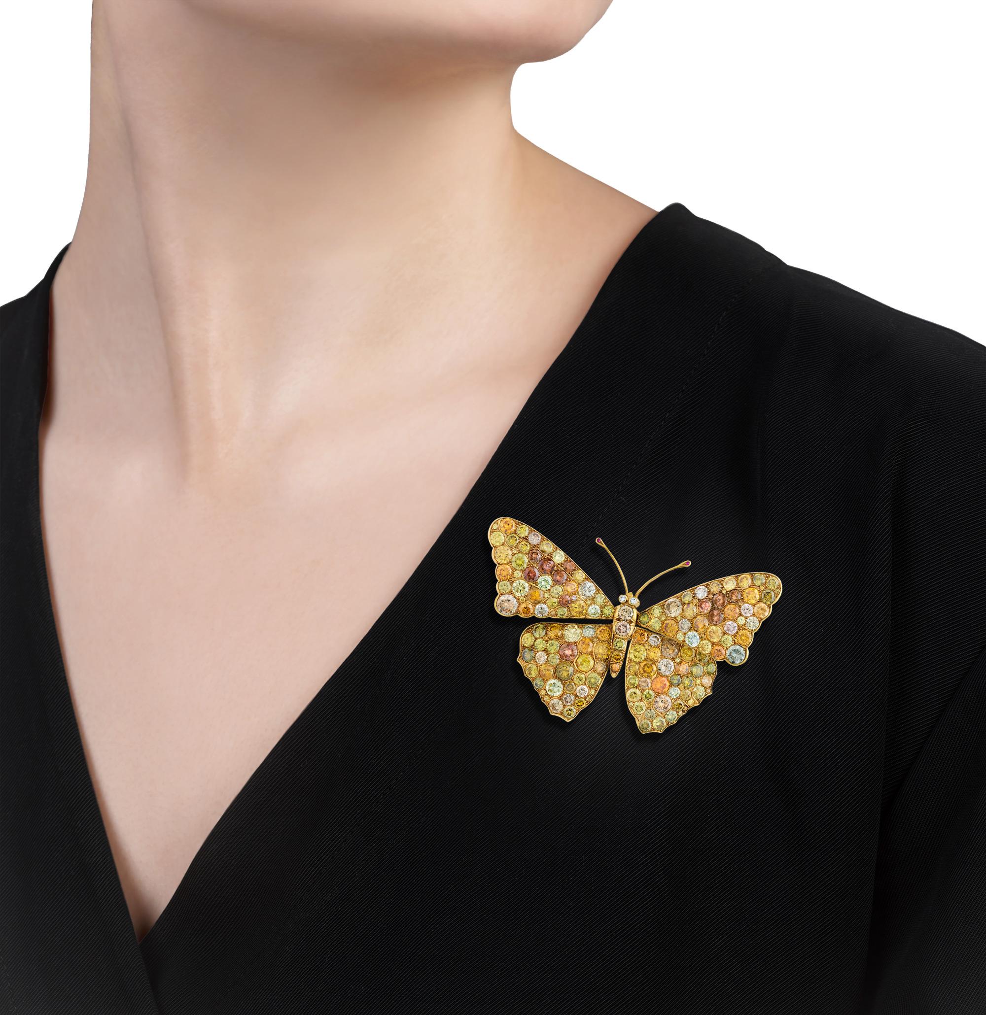 This exceptional yellow gold butterfly brooch from the 1970s is adorned with round brilliant cut white, champagne and cognac diamonds, totaling approximately 35 carats. The retro brooch is artfully enhanced by the inclusion of two cabochon rubies. A