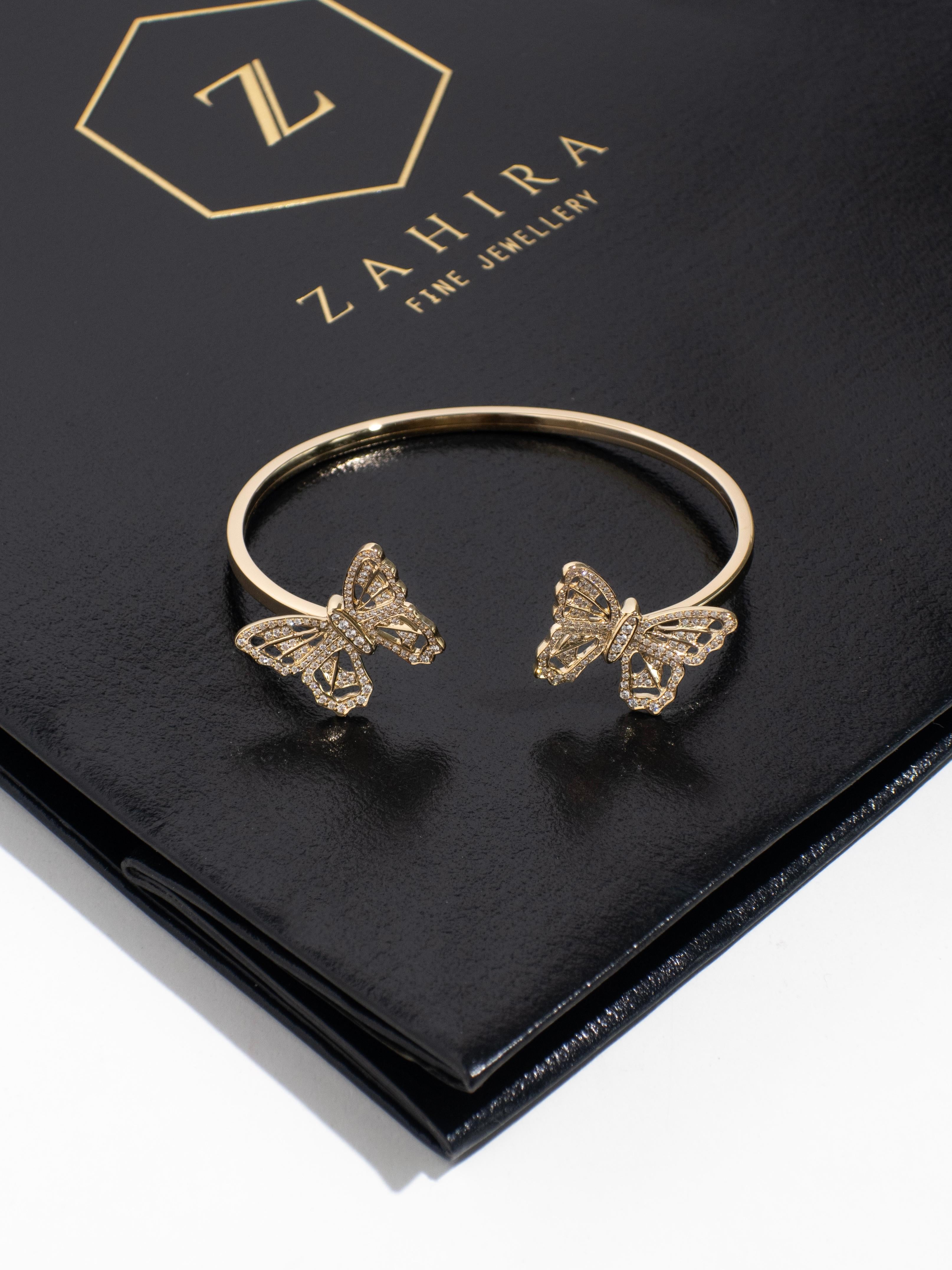 Ce luxueux bracelet en or jaune 18 carats présente deux papillons magnifiquement travaillés, chacun orné de diamants pavés étincelants. Symbolisant la transformation et la croissance, cette pièce rayonne d'élégance et de luxe. Ce bracelet est une