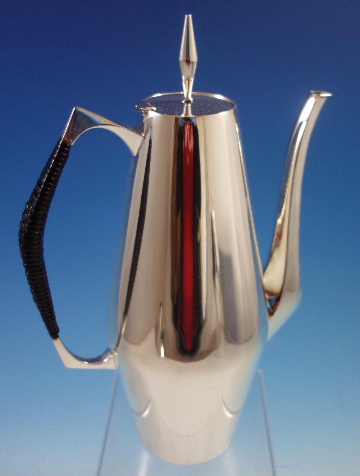 Diamond by Reed & Barton

Diamond by Reed & Barton Mid-Century Modern sterling silver four-piece tea set with black wrapped handles #440. This set includes:

One coffee pot: Weighing 29.4 troy ounces and measuring 11 1/2