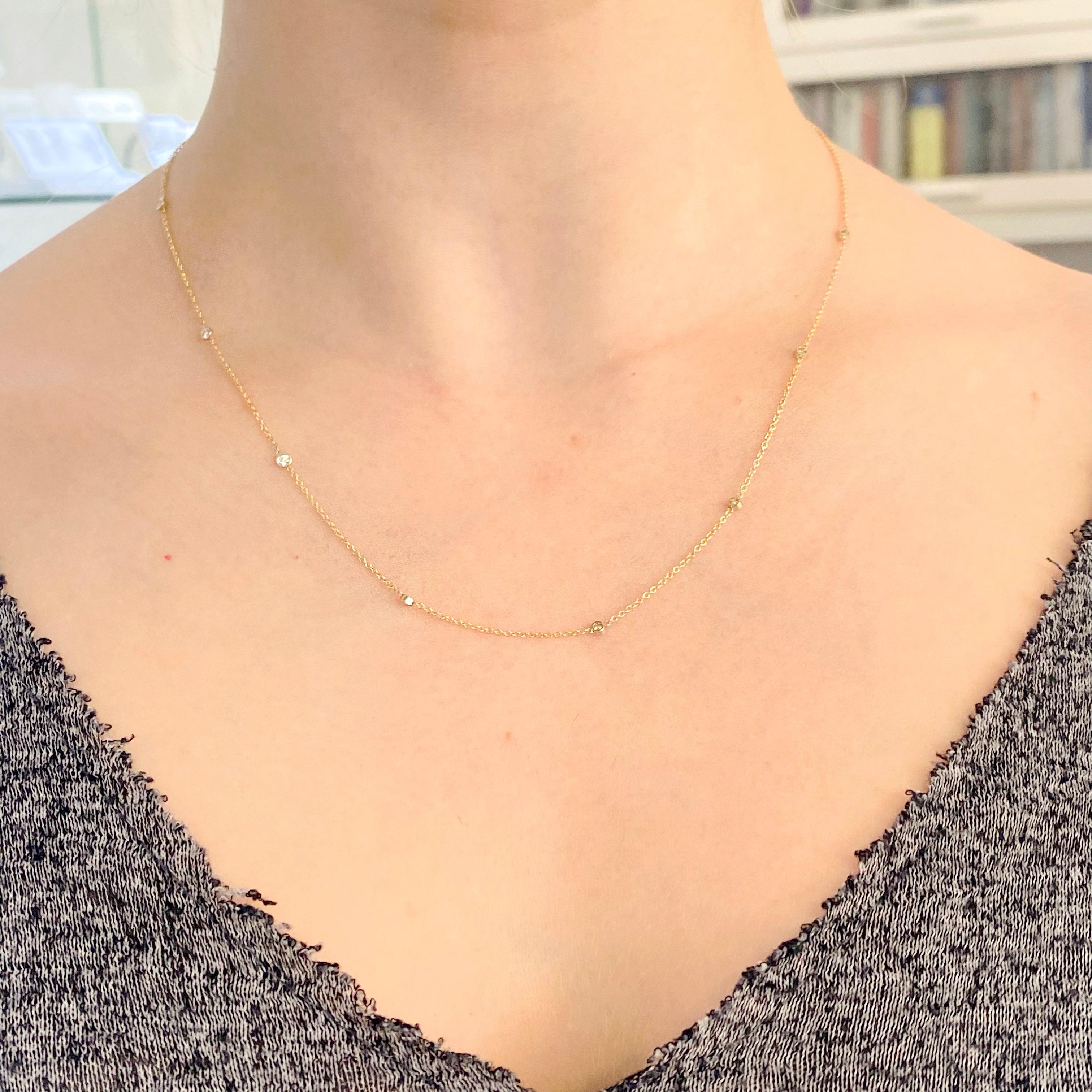 Diamonds by the yard necklace has 8 diamond stations that are set in 14 karat white gold bezels and connected with 14 karat yellow gold cable chain. The necklace is great by itself, or you can wear it with a pendant on it or you can layer it with