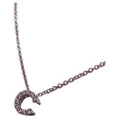 Collana con ciondolo a forma di "C" di diamante