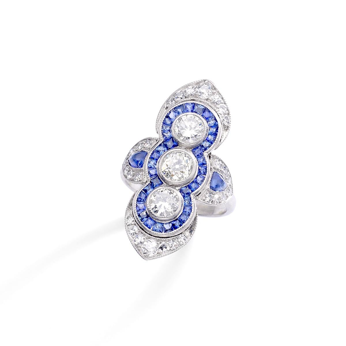 Diamante (tre diamanti principali di circa 2,00 carati in totale) circondato da uno zaffiro calibrato su anello in platino. 
20° secolo.

Misura dell'anello: 6 US