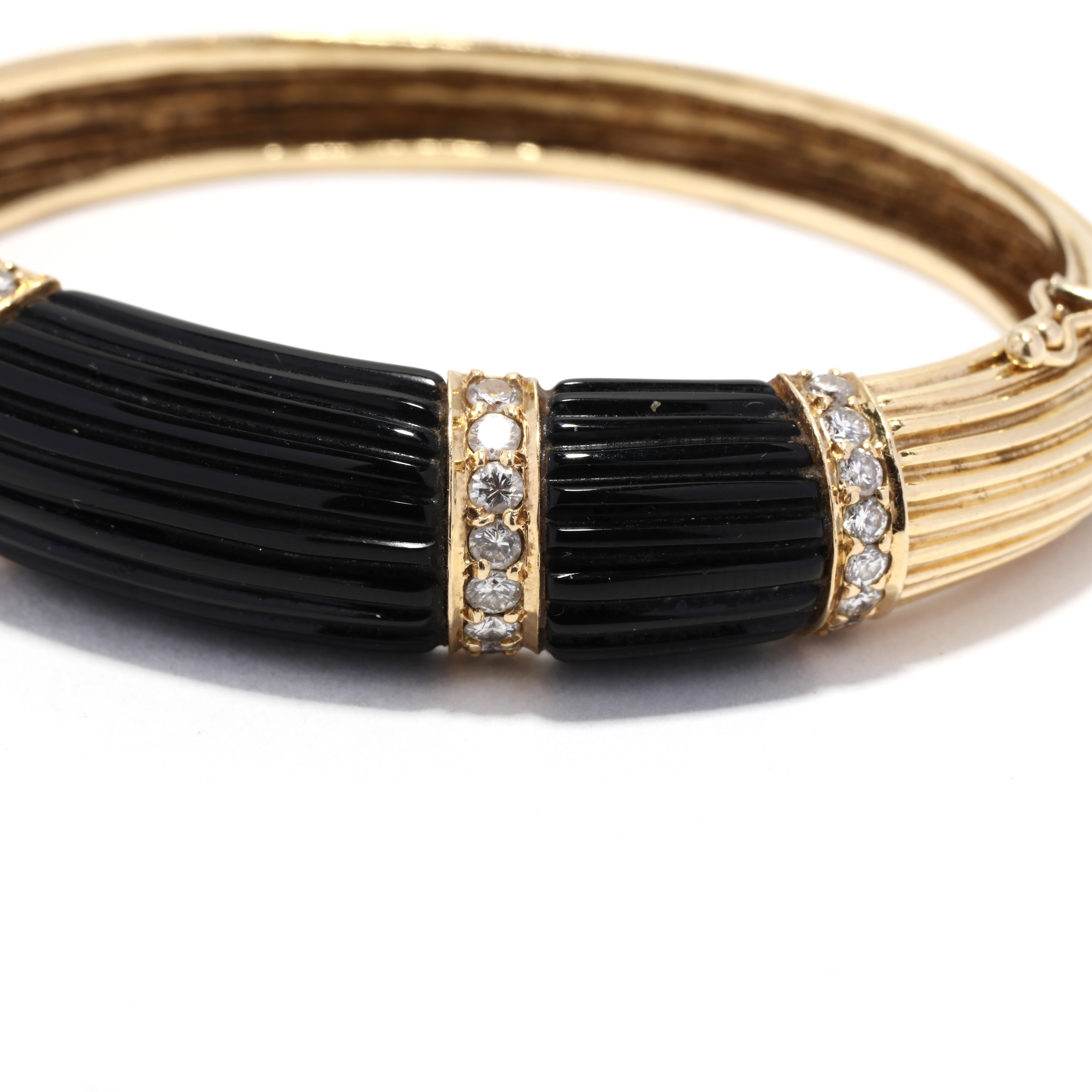 A vintage 18 karat yellow gold diamond and carved black onyx hinged bangle bracelet. This heavy gold bracelet features a tapered design with three pieces of horizontally carved black onyx stations with shared prong, round brilliant cut diamond rows