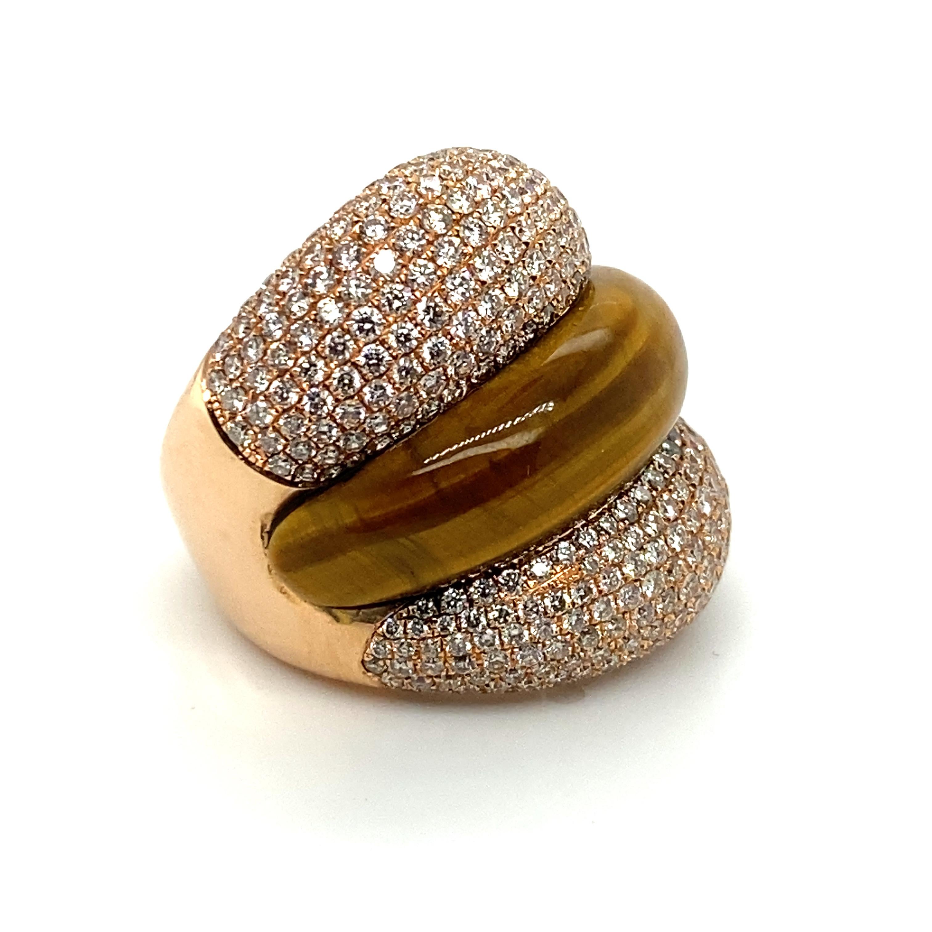 This beautifully detailed 18k gold cocktail ring consists of two 'bands' of pave-set diamonds totaling approximately 3.5cts, separated by a band of cat's eye carved to fit the dimensions of the ring.  

One of the tell-tale hallmarks of quality