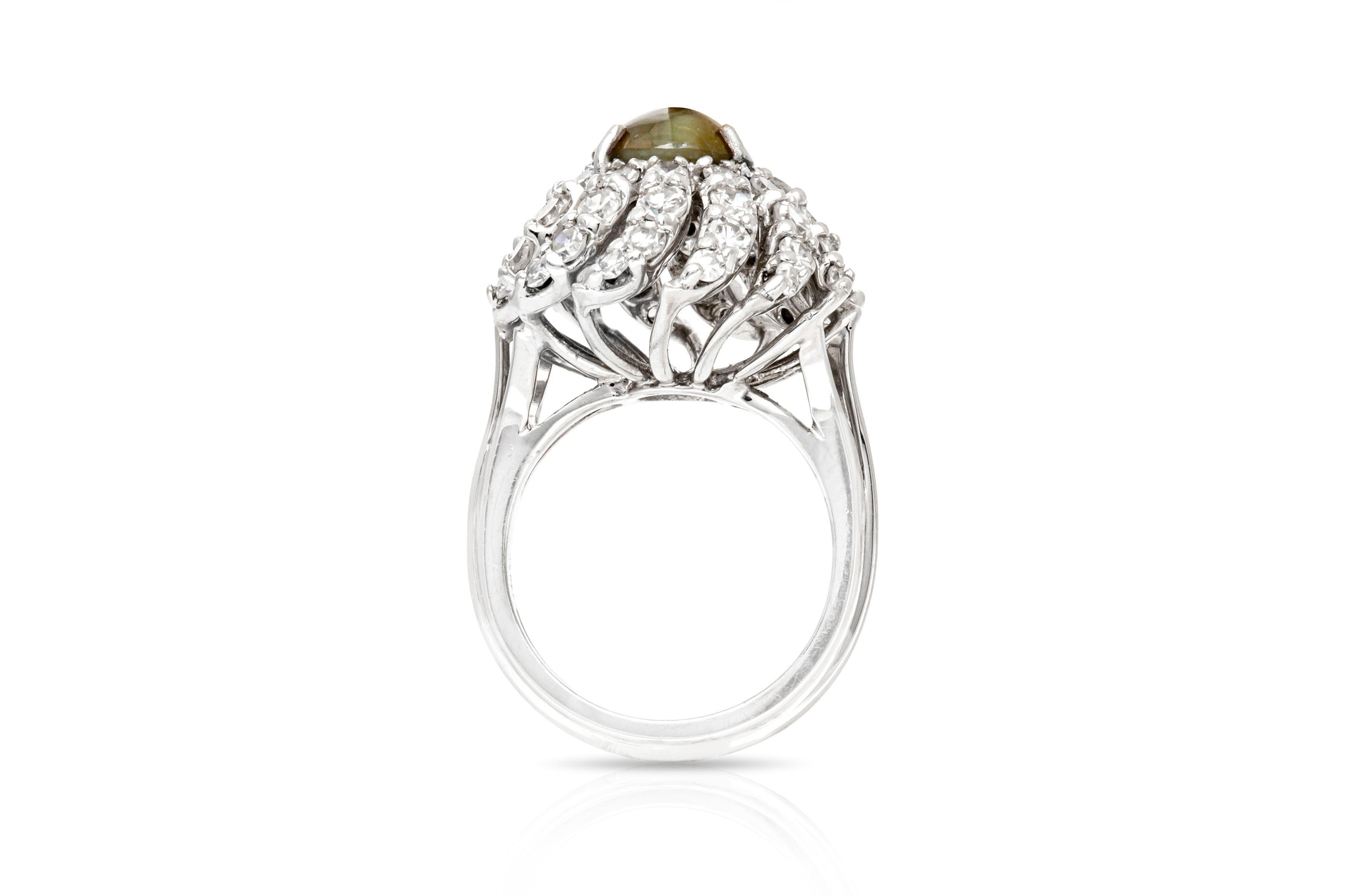 Ring, finally crafted in platinum with a cat eye center stone weighing approximately a total of 2.50 carat and diamonds weighing approximately a total of 2.00 carat. Circa 1950's.